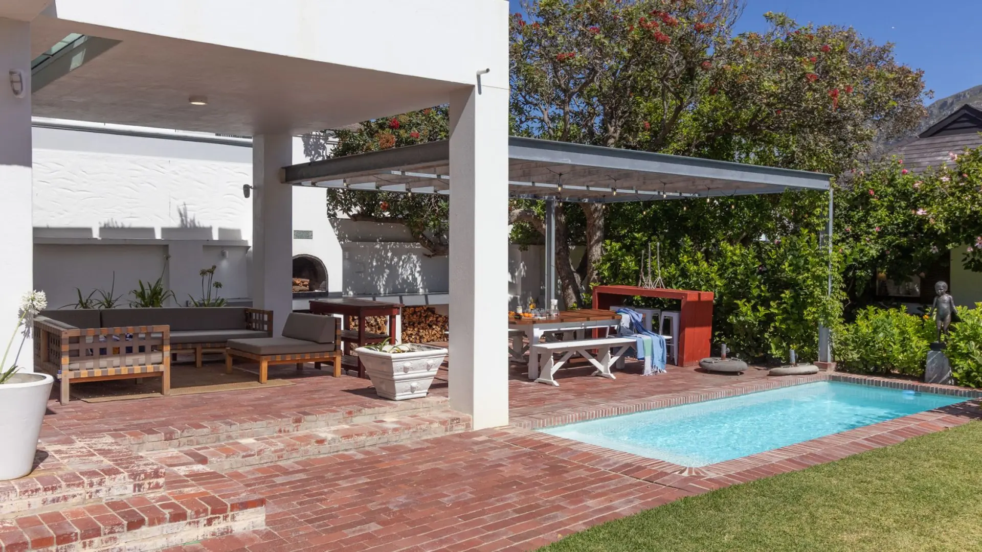 Outdoor patio with swimming pool, dining area, and seating.