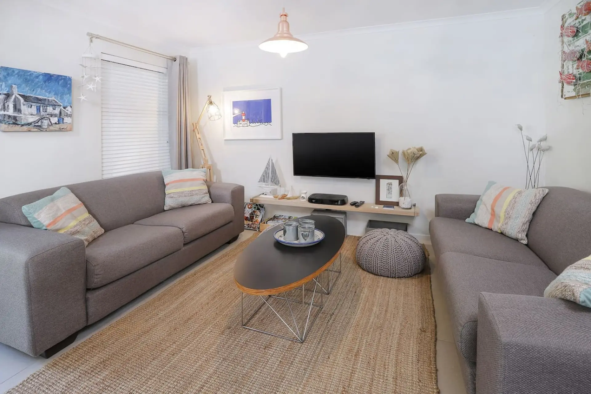 A living room with two gray sofas, a coffee table, and a TV.