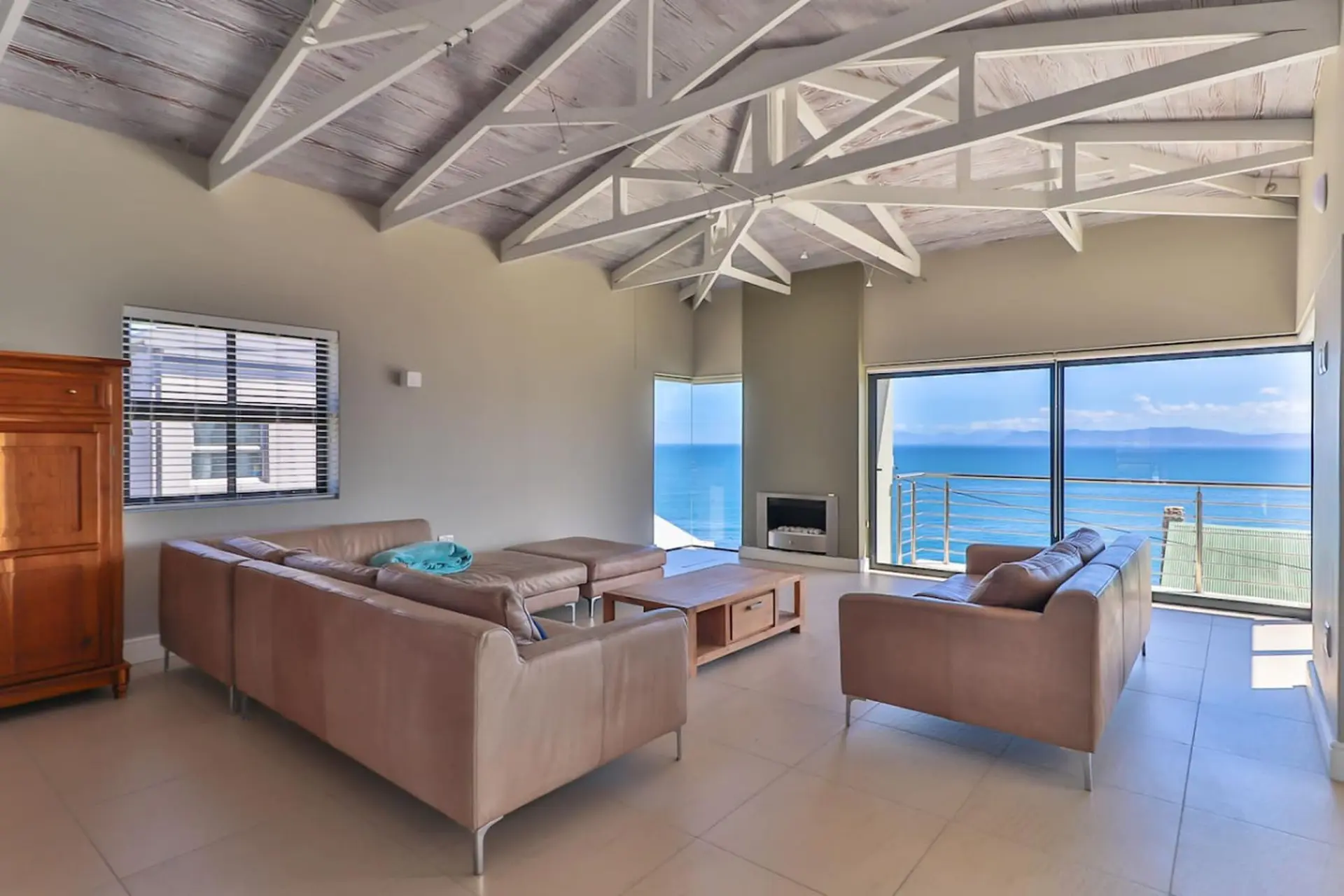 A modern living room with large windows overlooking the ocean.