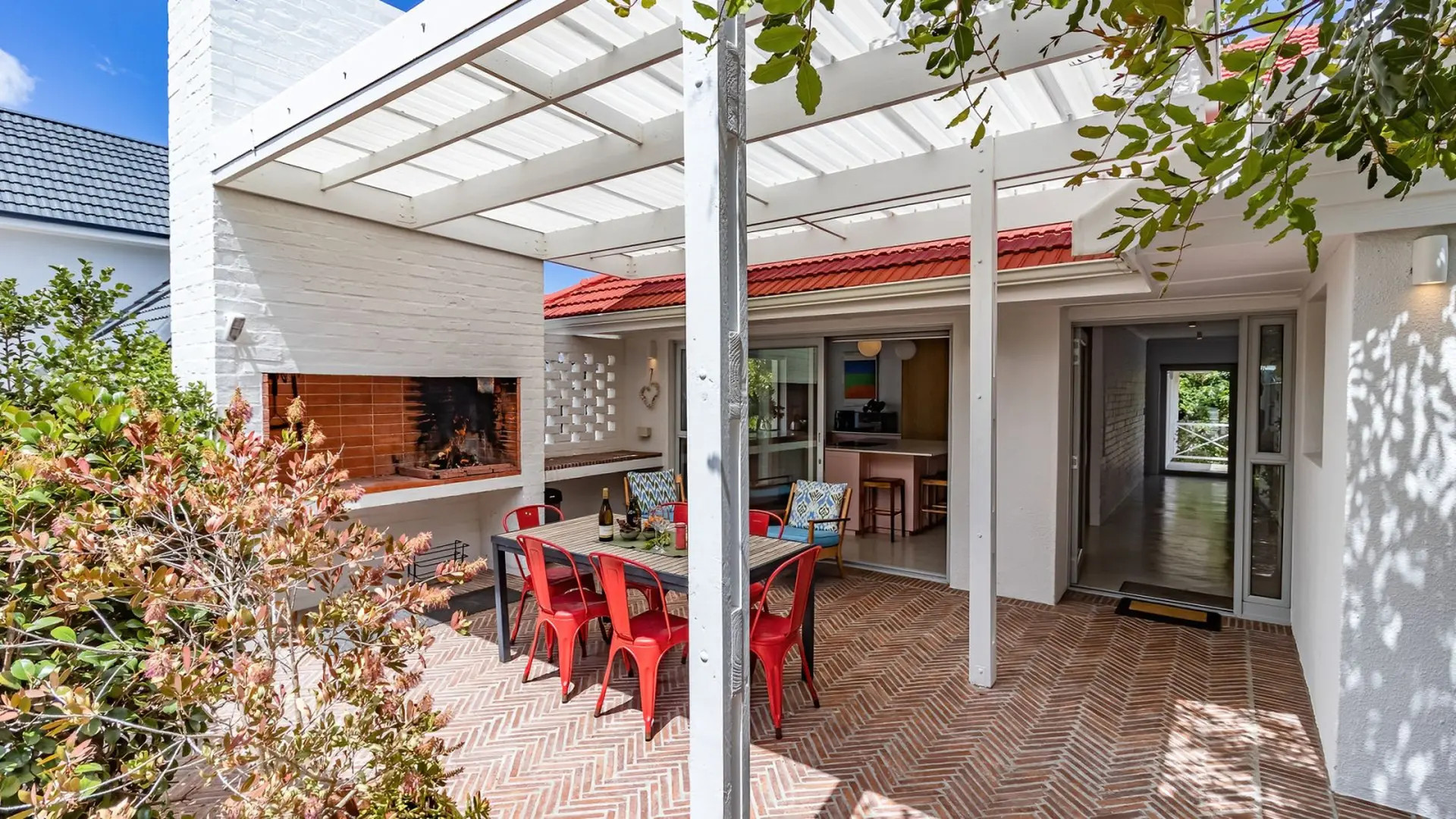 Outdoor patio with dining table, chairs, and built-in fireplace.