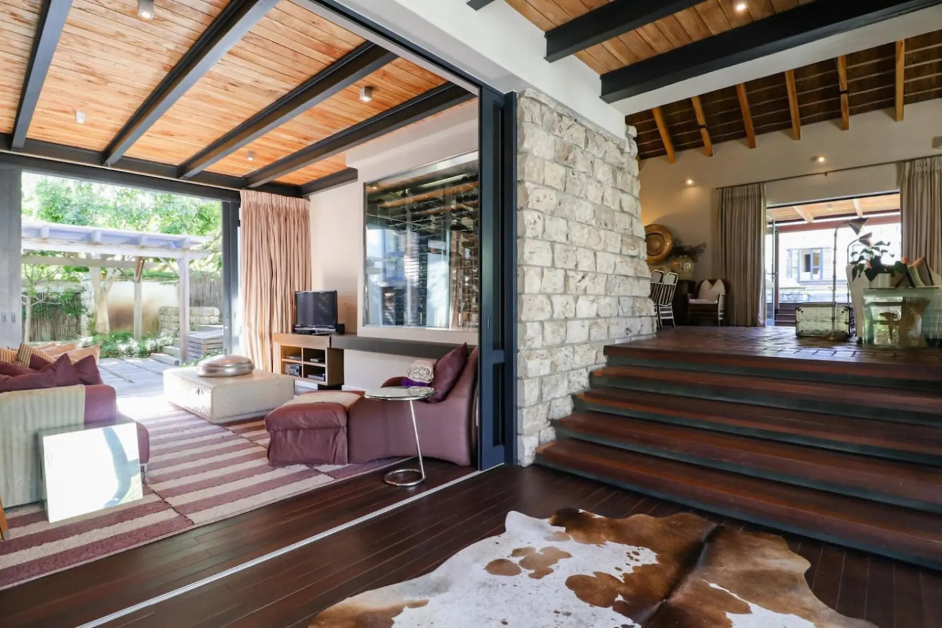 Living room with an open floor plan, floor-to-ceiling sliding doors leading to an outdoor patio.