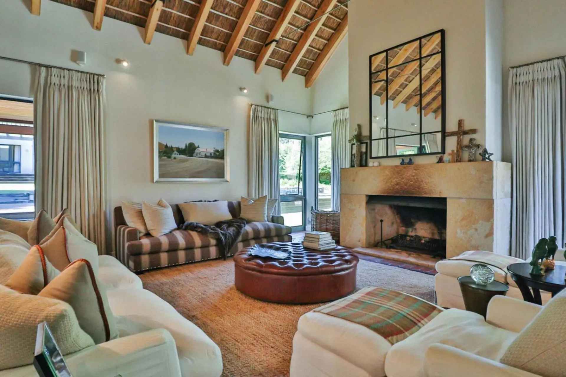 Living room with fireplace, tufted ottoman, and striped sofa.
