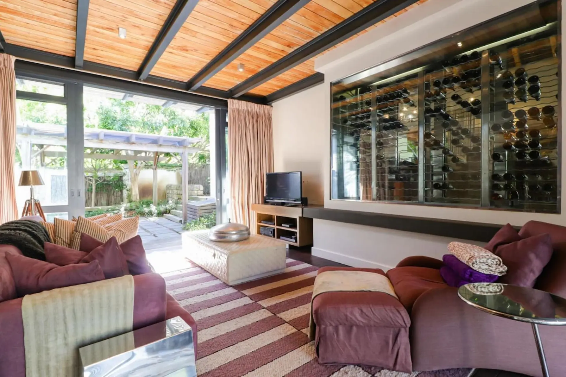 Interior of a living room with a wine display and plush seating.