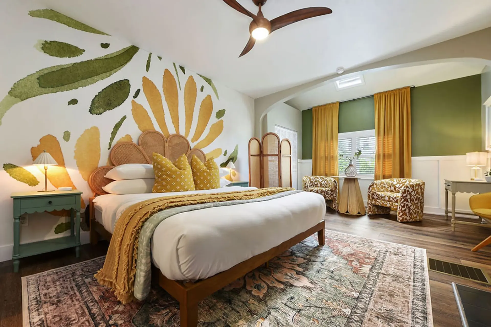 A bohemian bedroom with a mural and rattan headboard.