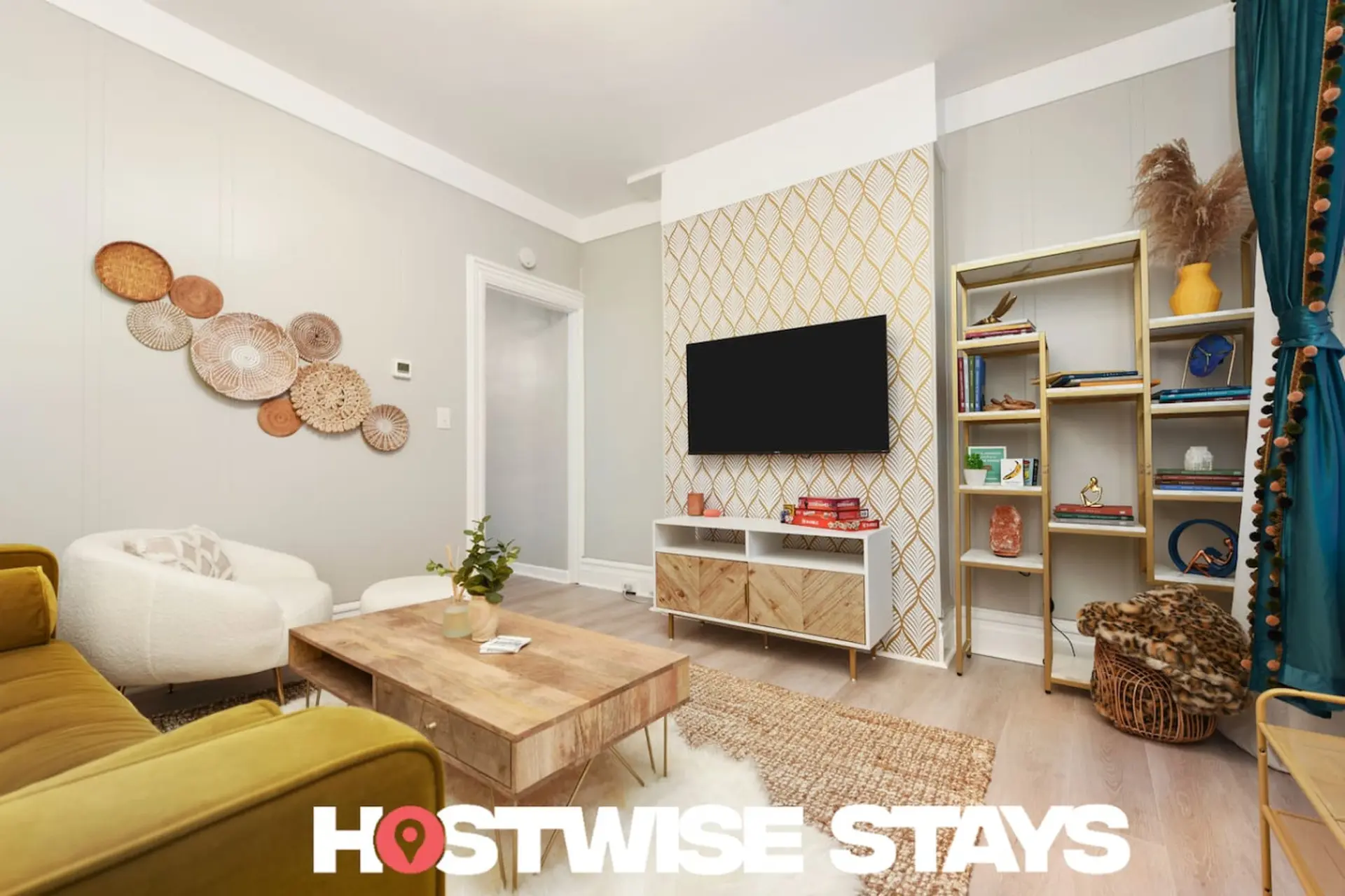 A living room with a mustard yellow couch, a white armchair, a coffee table, and a TV on a stand.