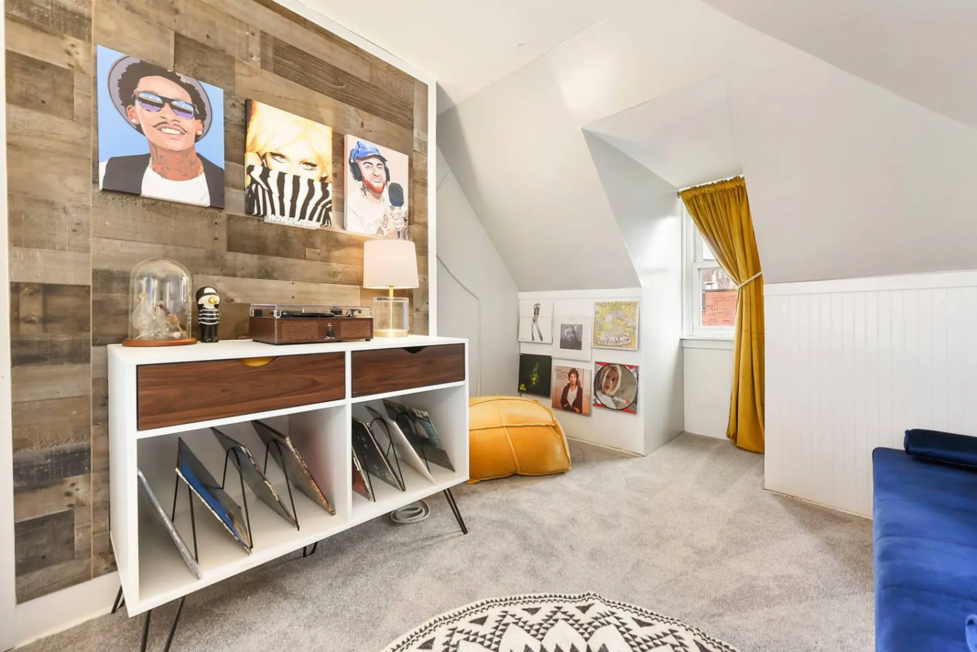 A record player on a white cabinet with records displayed below.