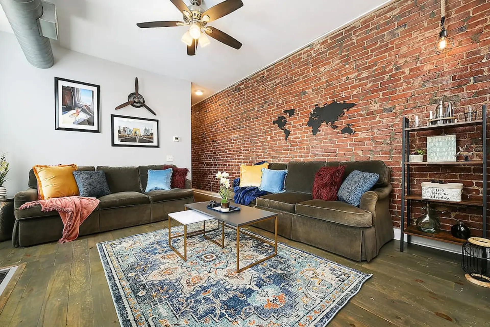 Cozy living room with a sectional couch, brick wall, and world map art.