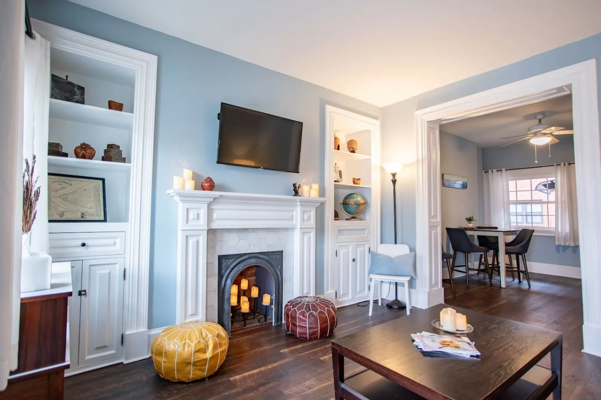 Living room with a fireplace, built-in shelves, and a dining area.