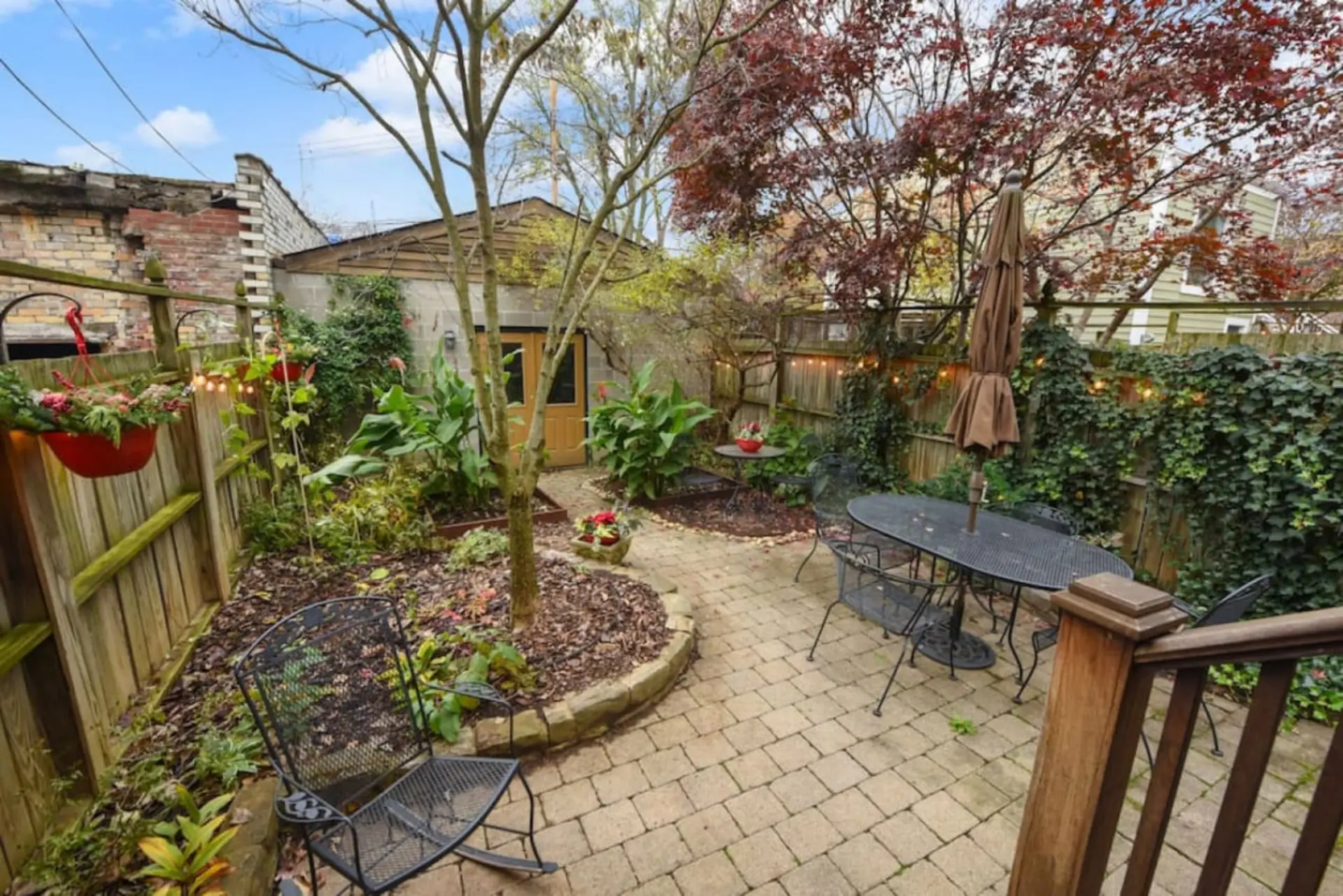 Outdoor patio with seating, plants, and a garage.