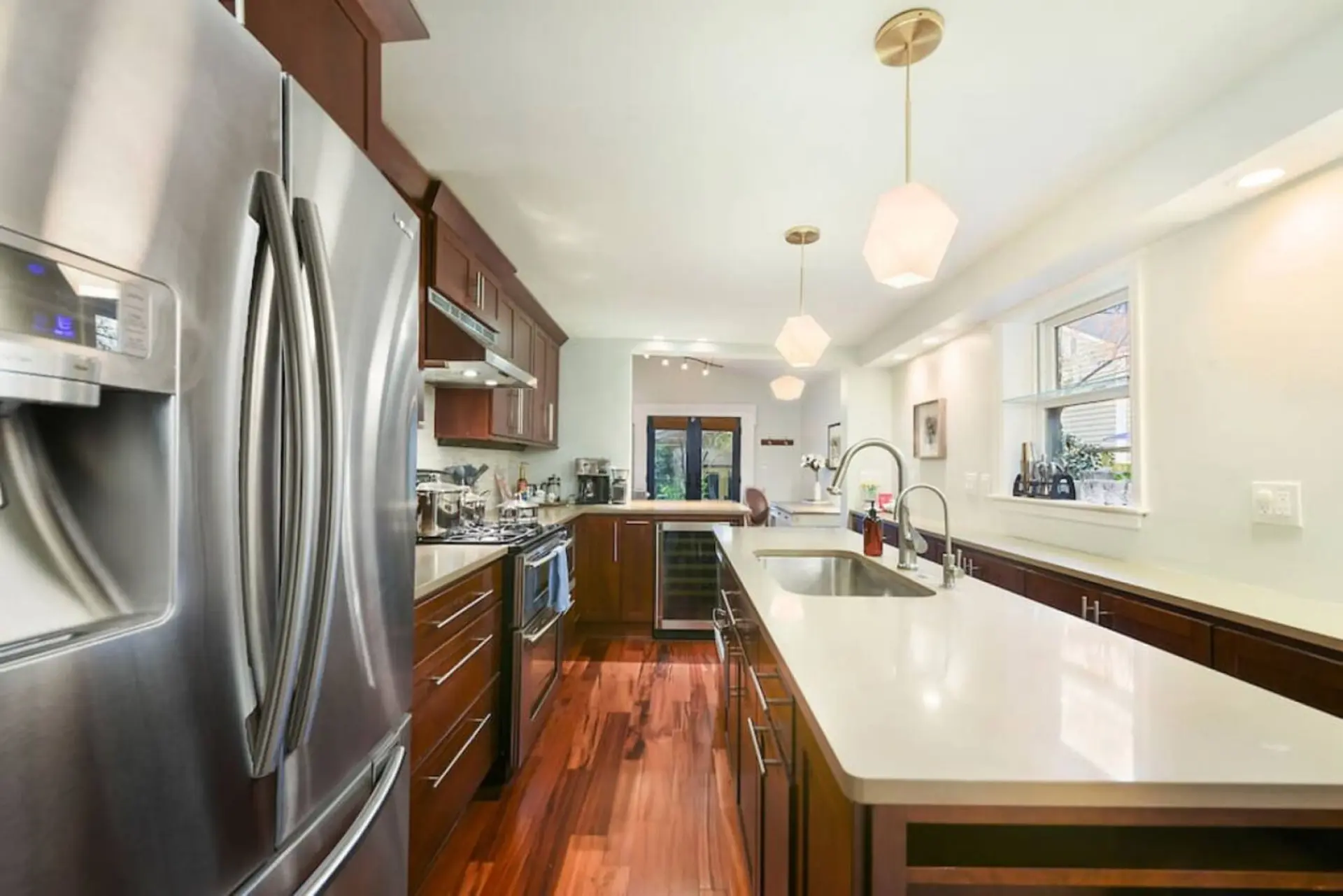 A modern kitchen with stainless steel appliances and dark wood cabinetry.