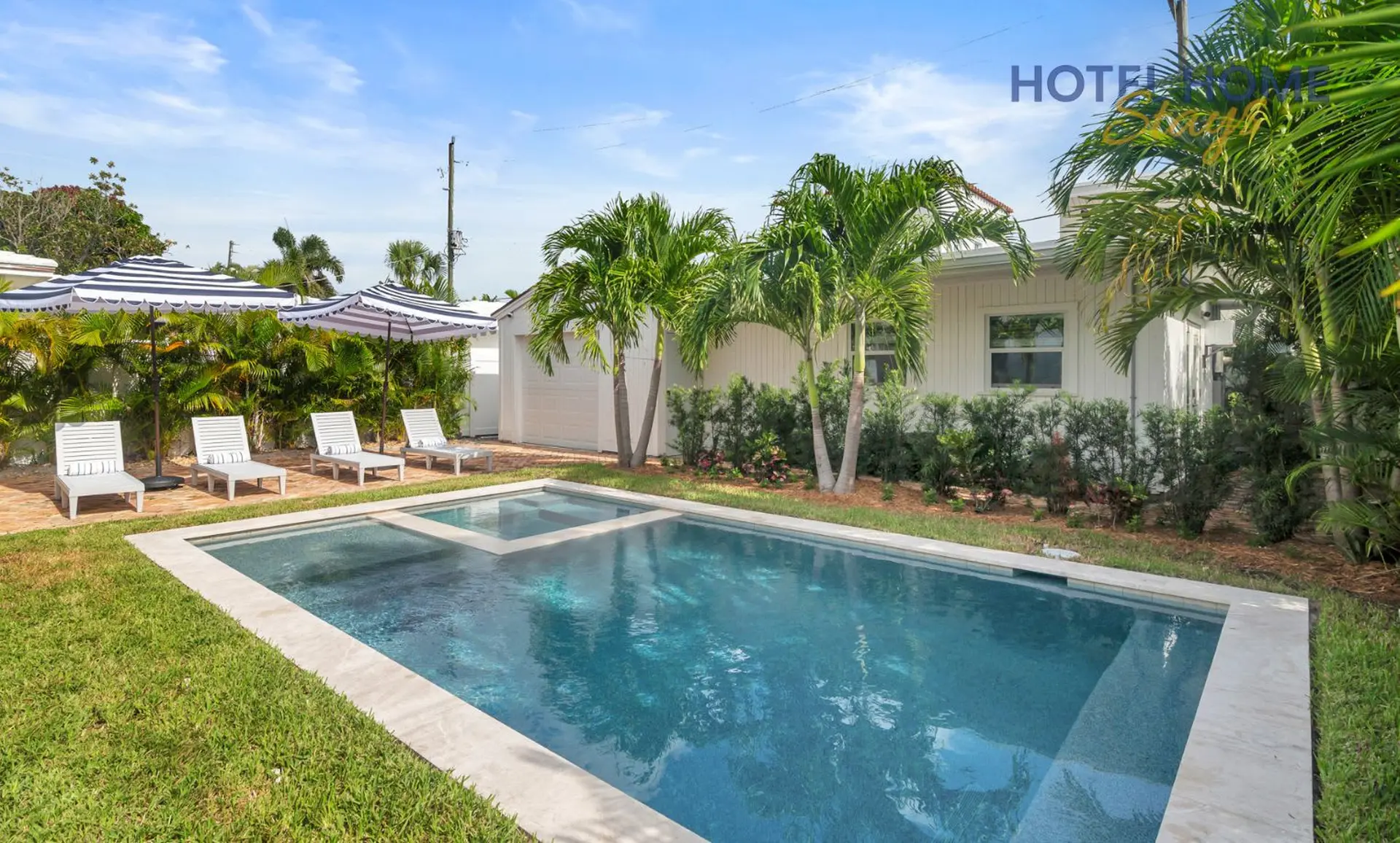Backyard pool with lounge chairs and umbrellas.