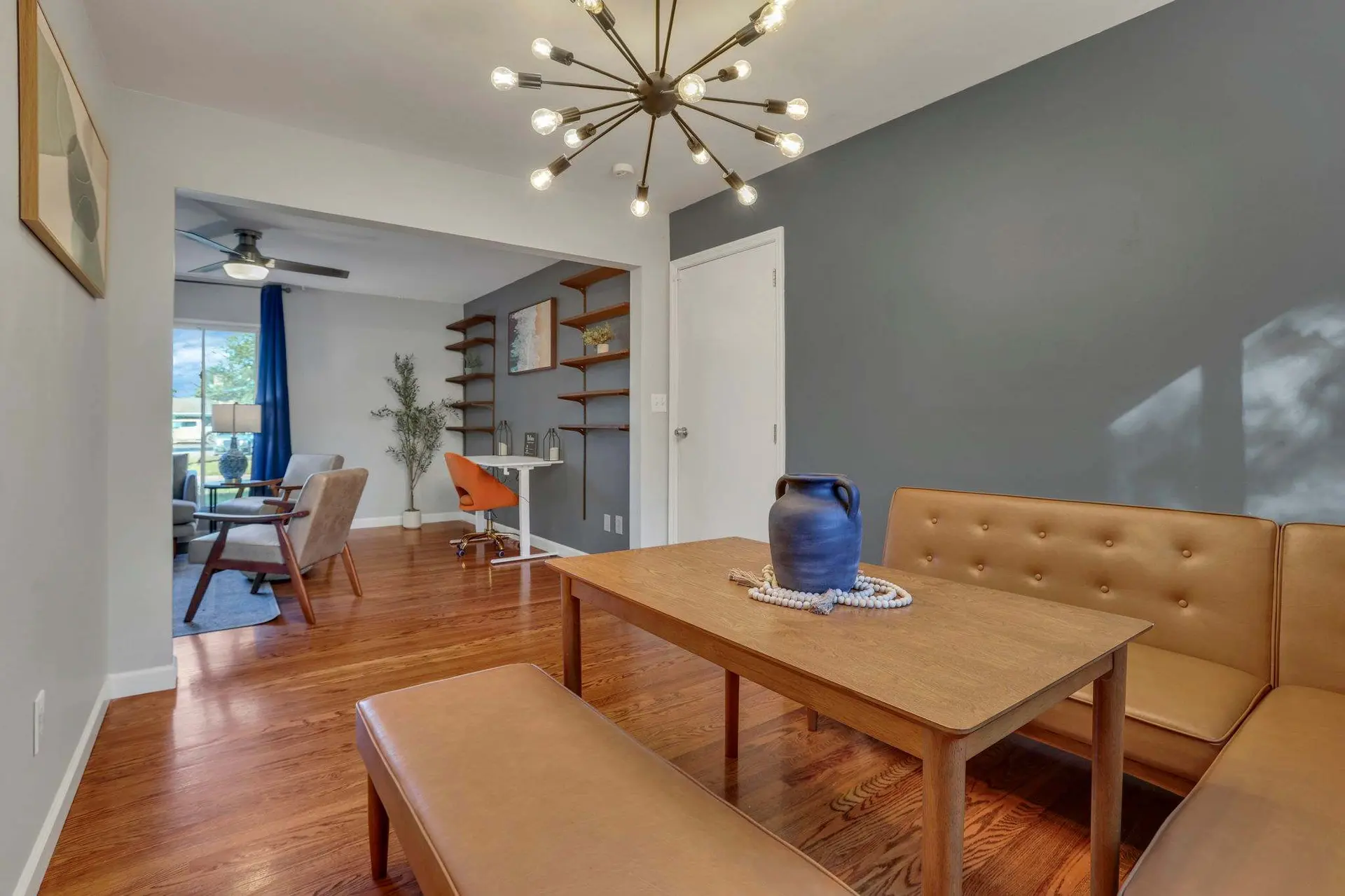 Dining area with wooden table, bench seating, and large vase.