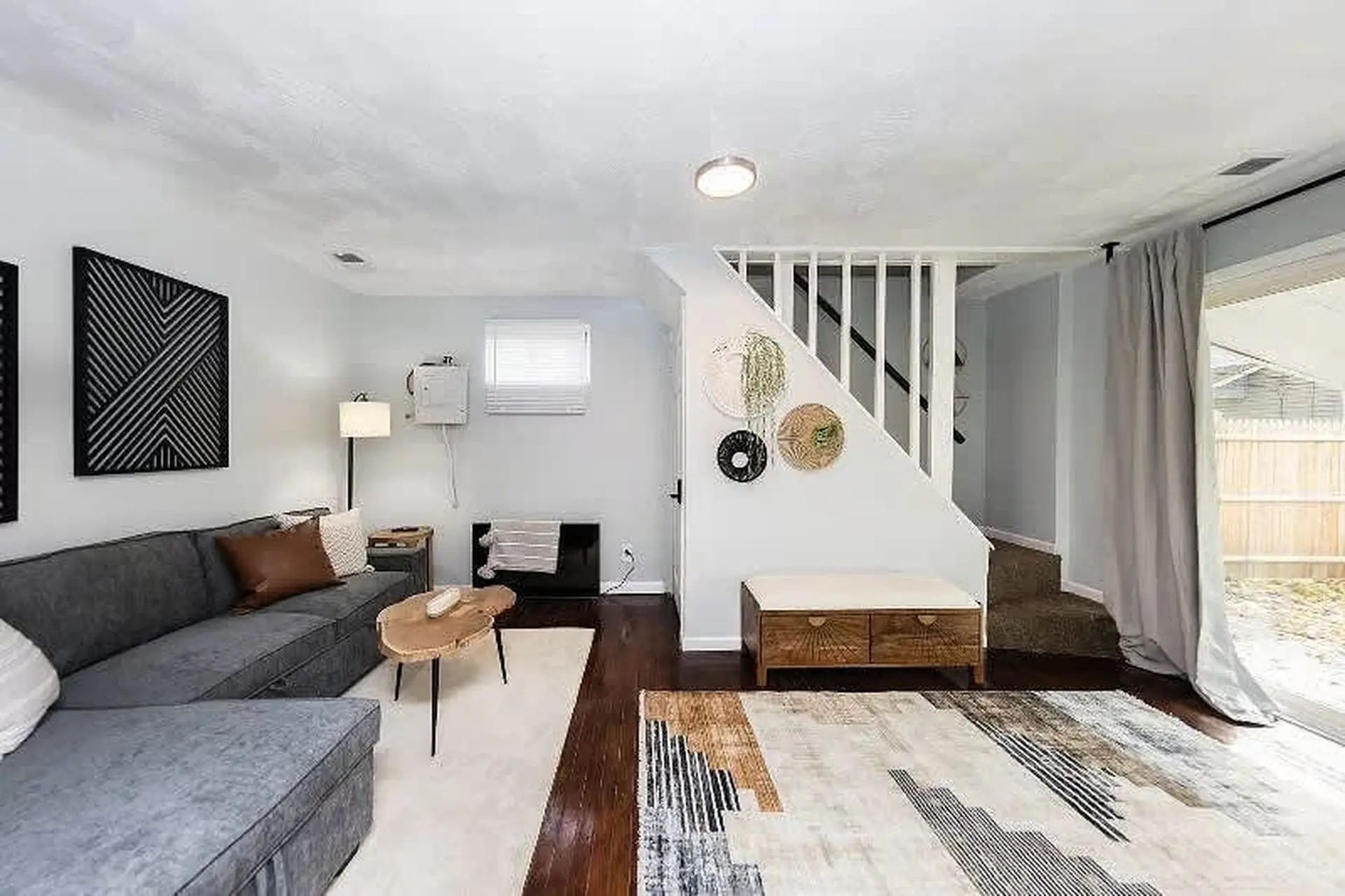 Modern living room with a sectional sofa, coffee table, and staircase.