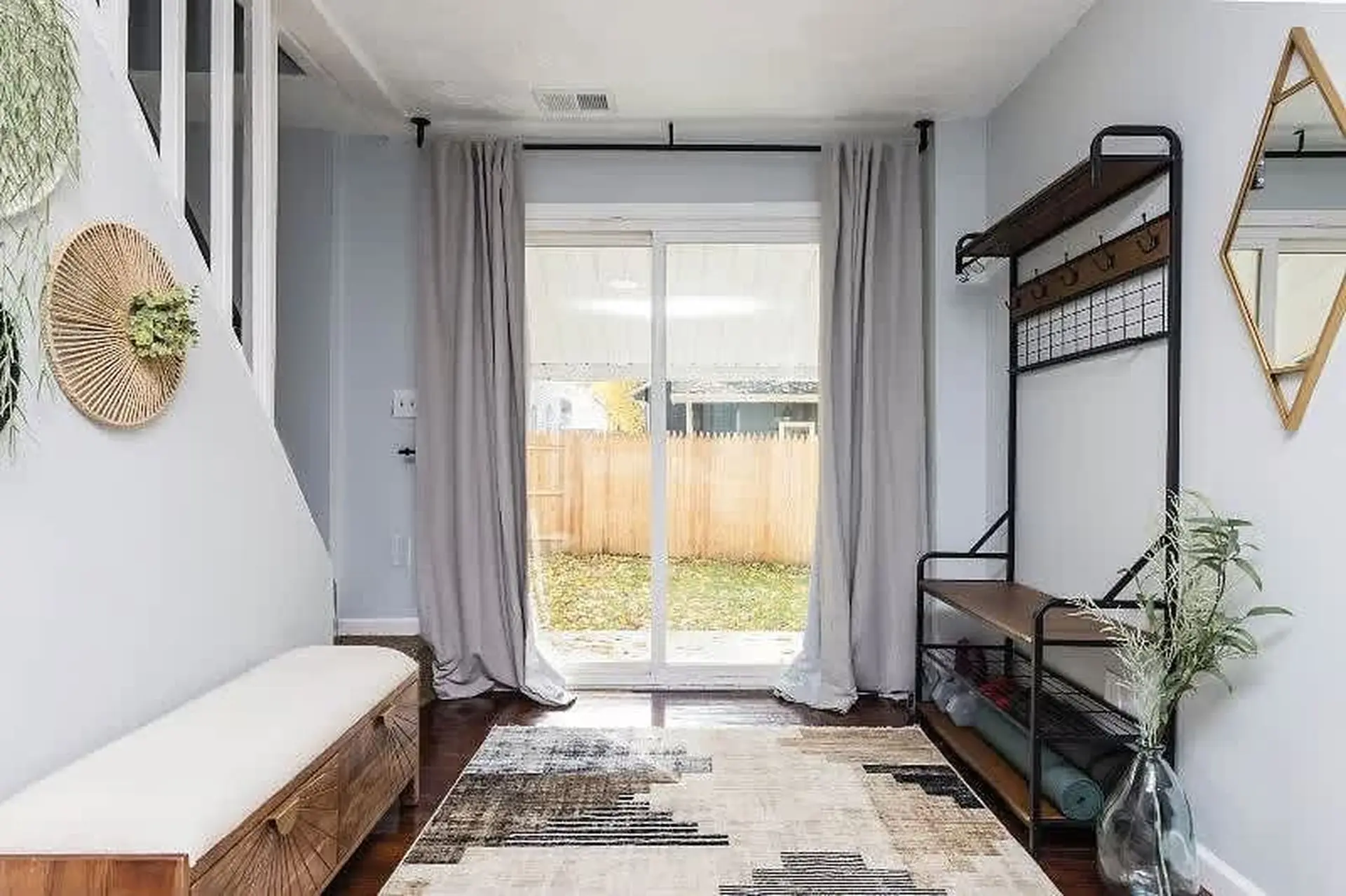 A narrow bench with a white cushion sits to the left of a sliding glass door.