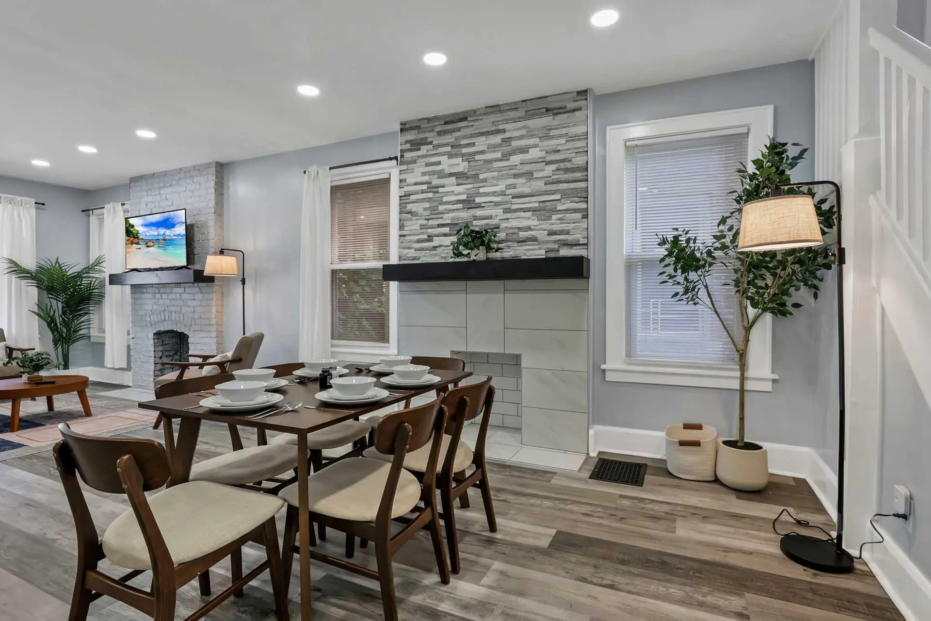 Dining room with a table set for dinner, fireplace, and television.