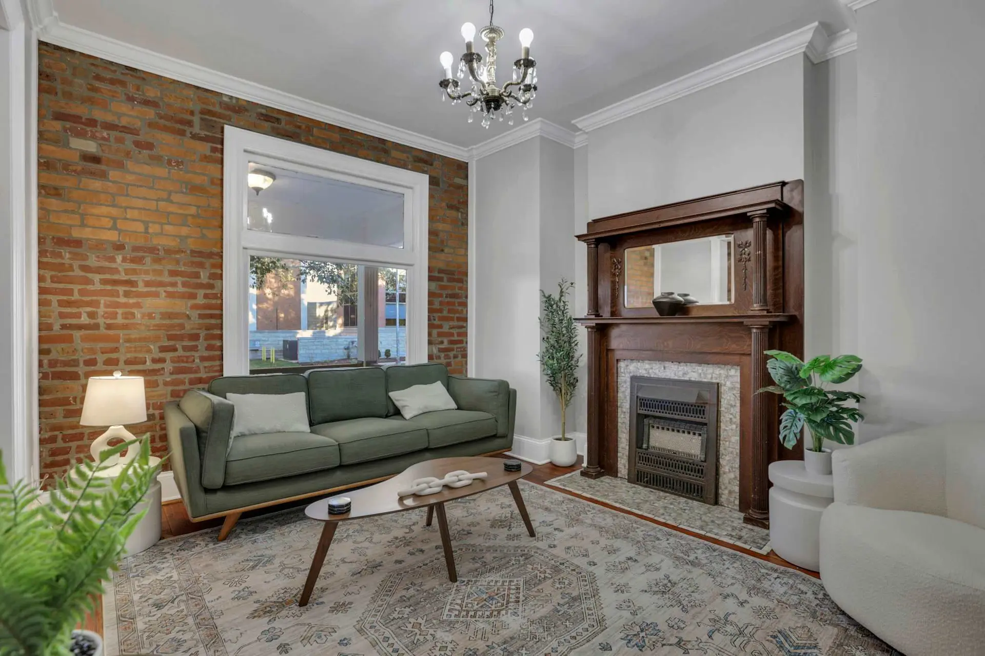 A vintage living room with exposed brick, a green sofa, and a wooden fireplace.