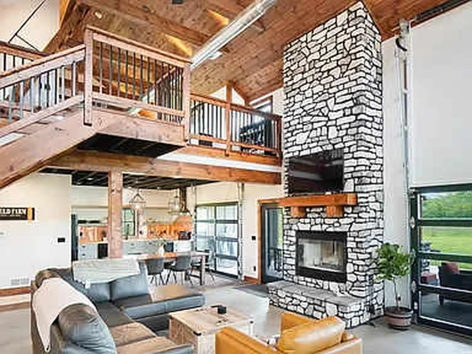 Certainly! This image features a **large, open living room with a rustic, modern aesthetic**.

Here'