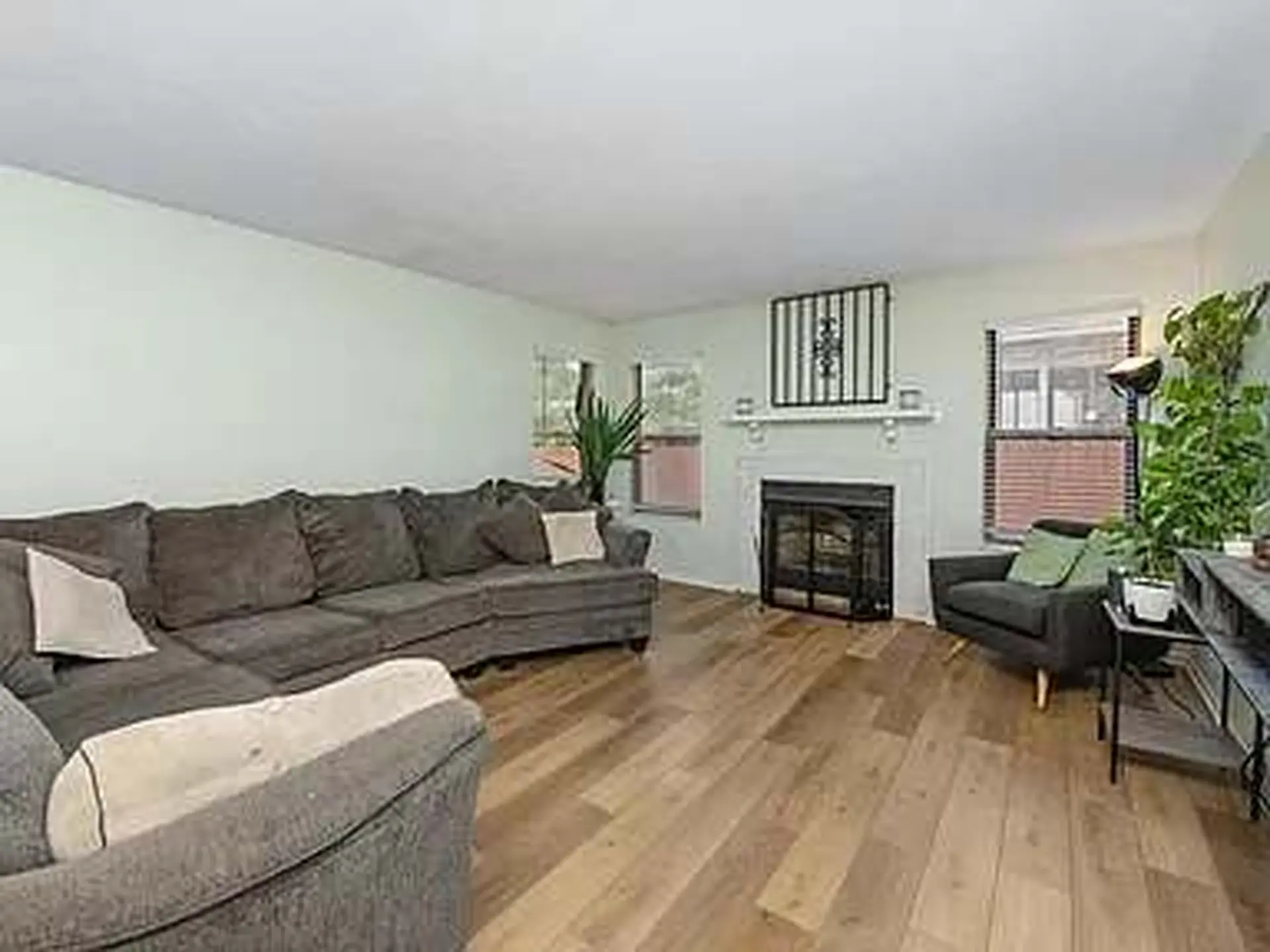 Certainly! Let's analyze the image you sent. It's a living room with a sectional sofa, a fireplace, 