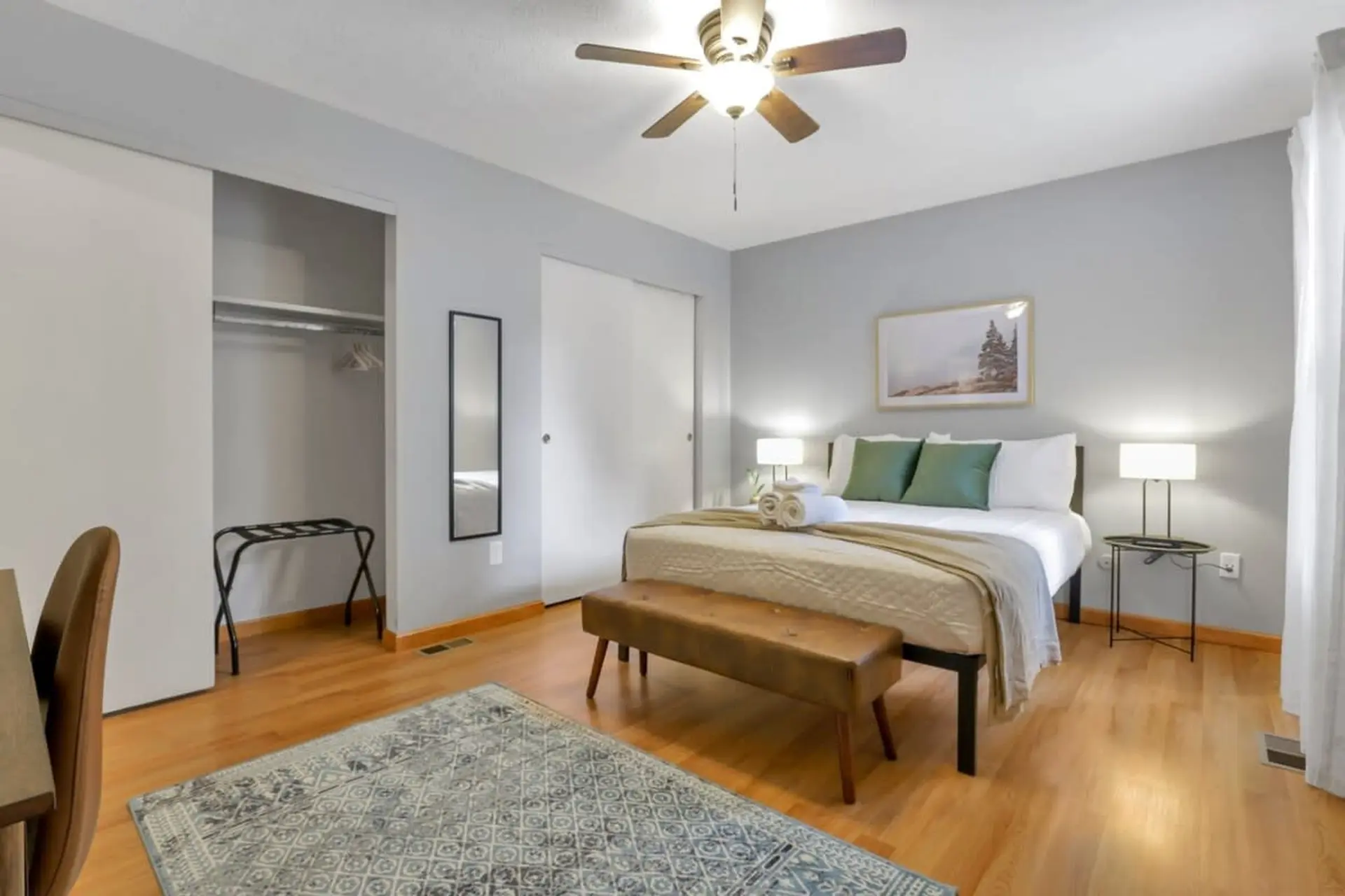 Bedroom with a king-size bed, ceiling fan, and artwork.