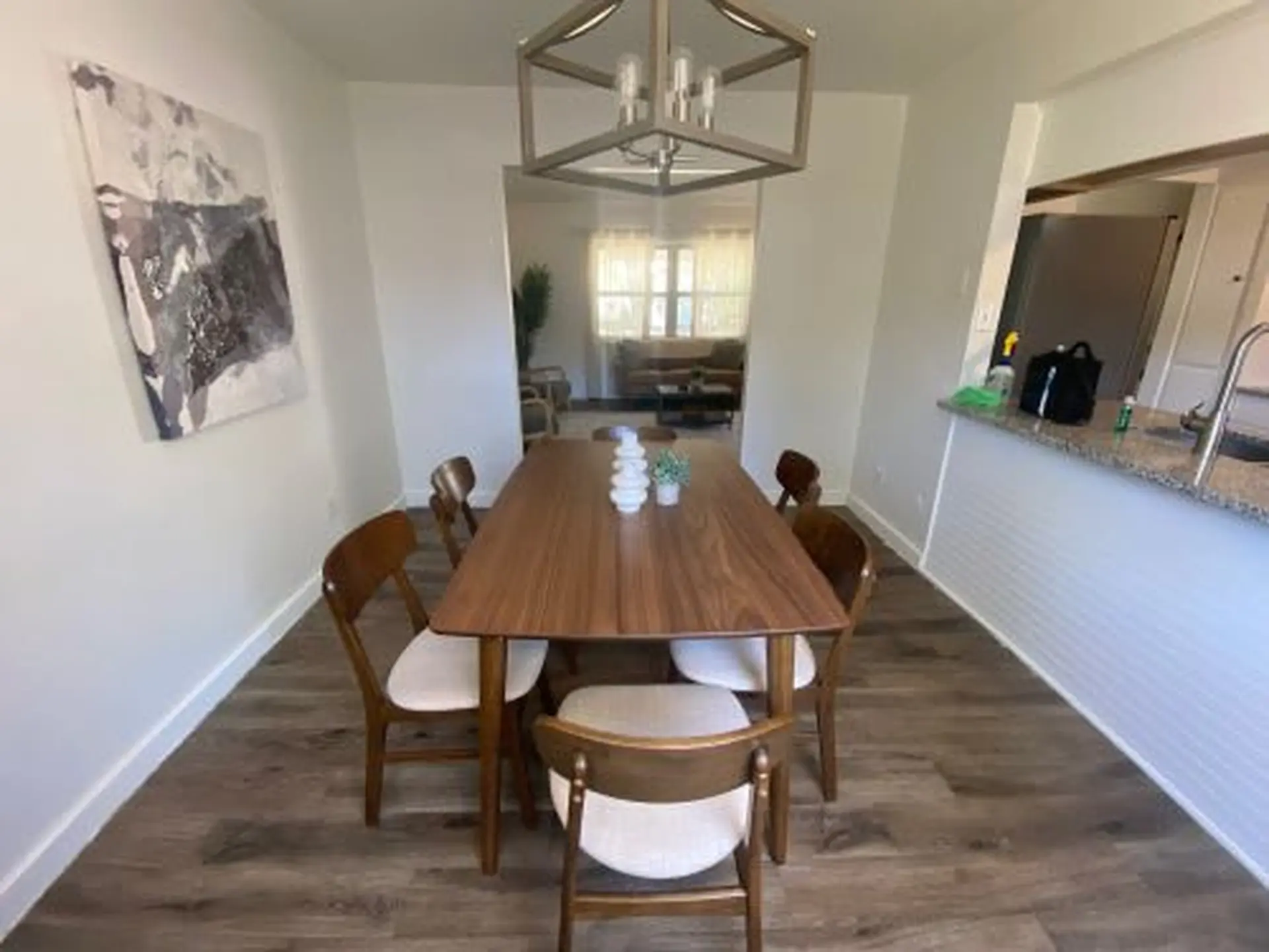 A dining table with chairs in a room with artwork.