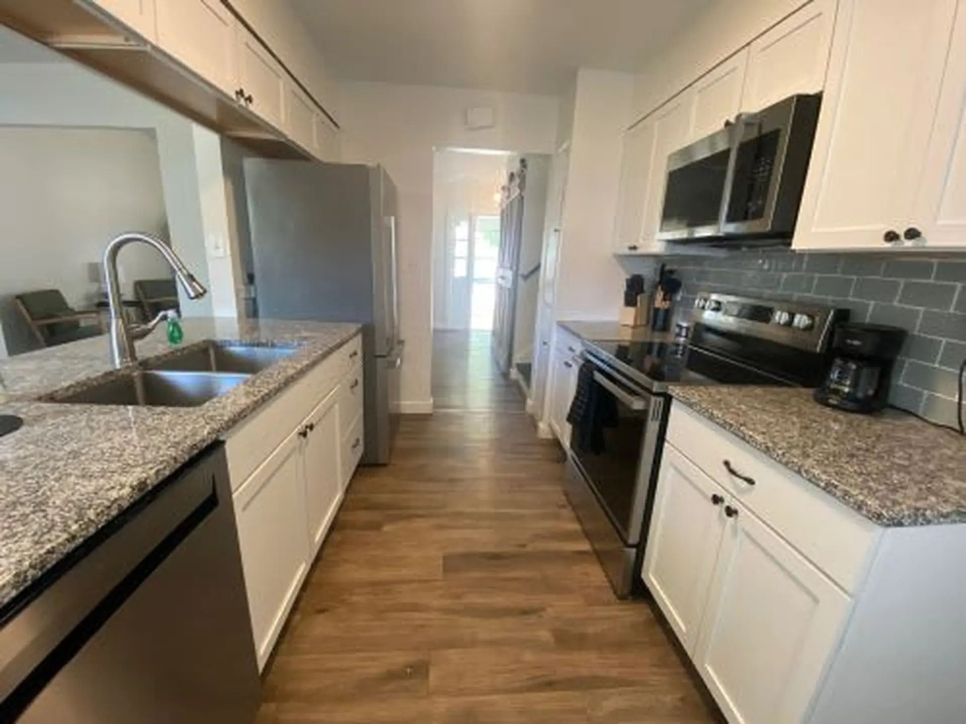 Kitchen with white cabinets, stainless steel appliances, and granite countertops.