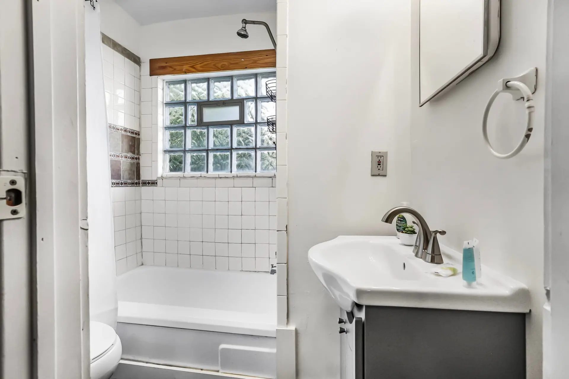 A compact bathroom with a bathtub, toilet, and sink with a vanity.