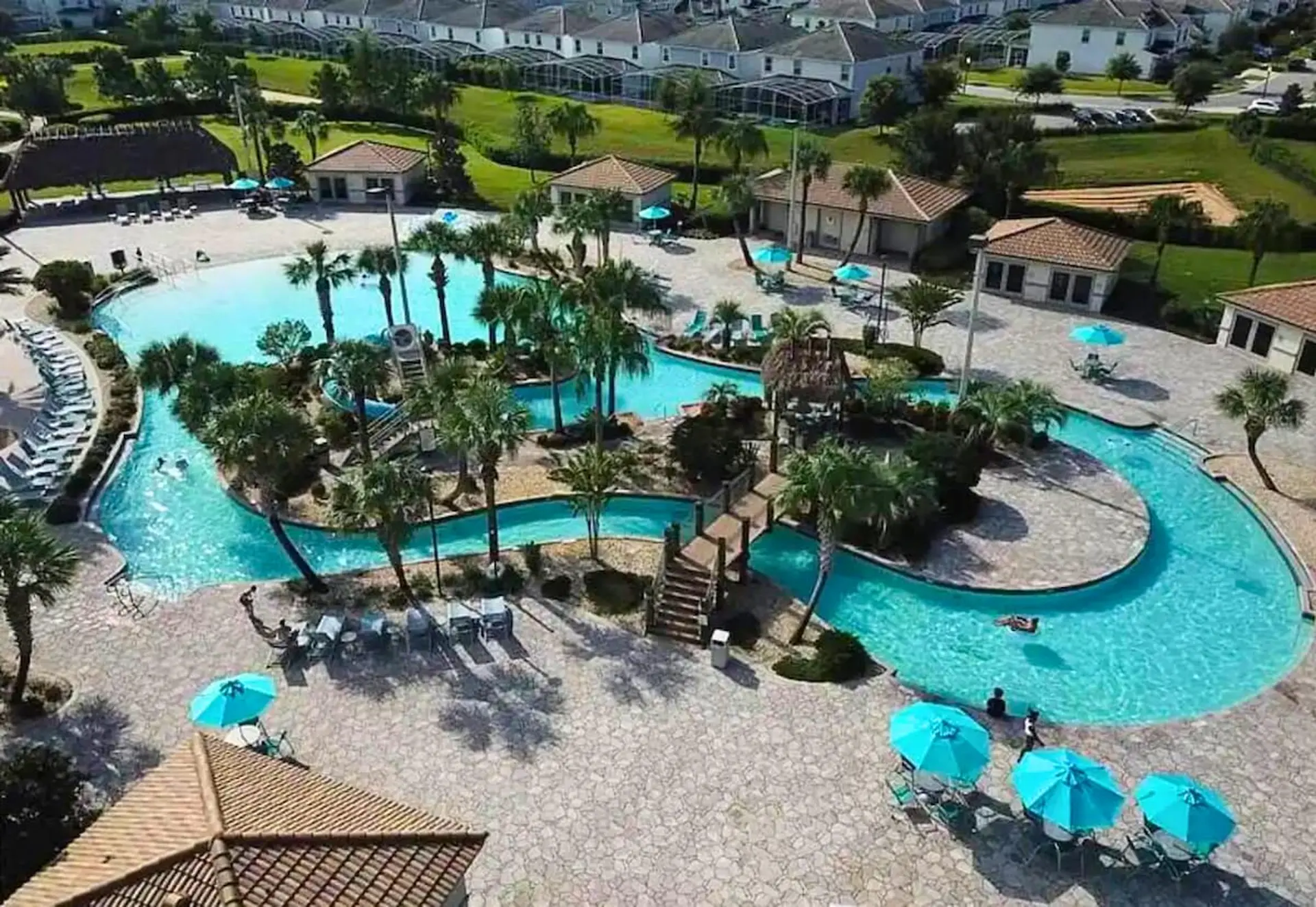 Aerial view of a resort pool complex with lazy river, slides, and lounge chairs.