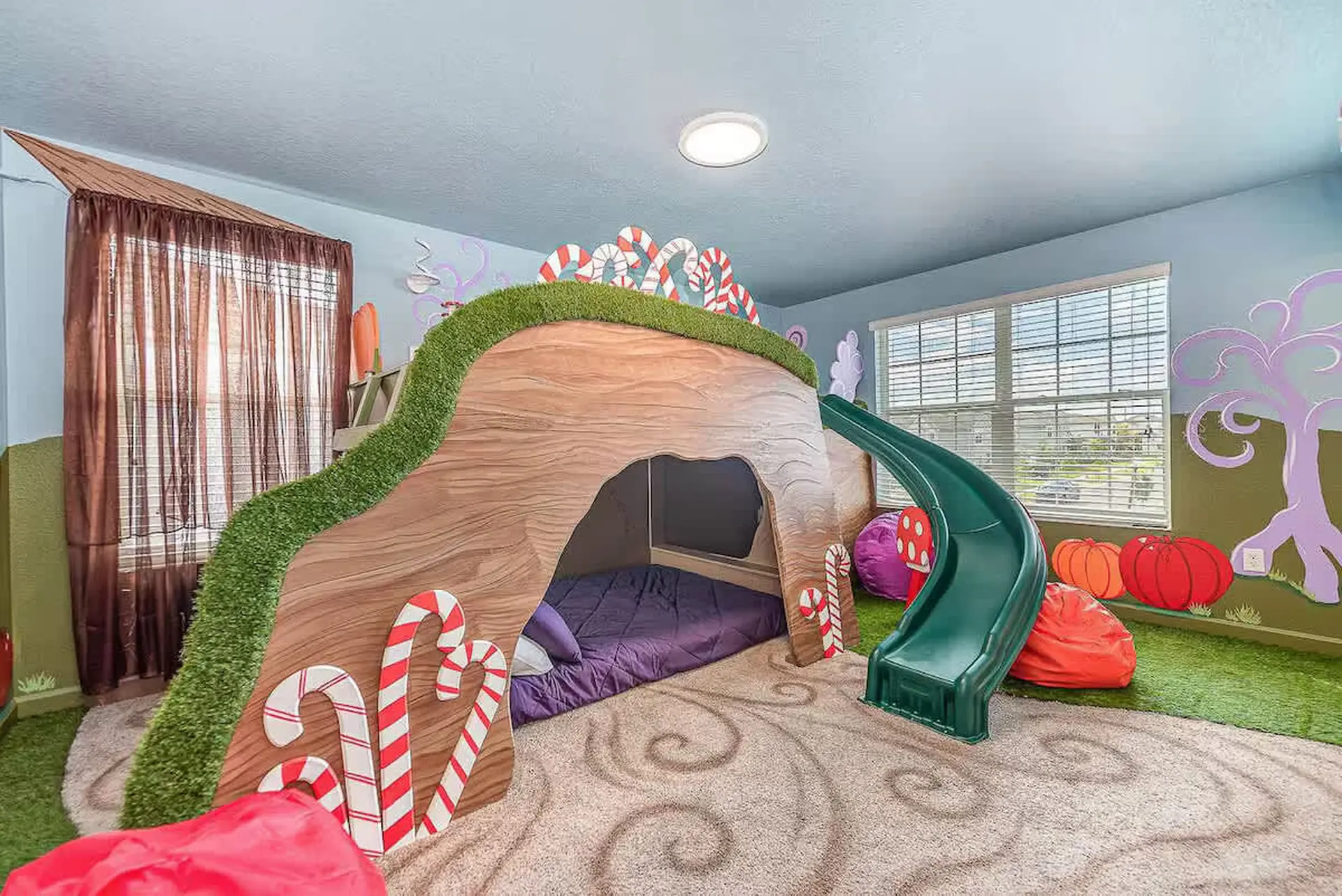 Children's whimsical bedroom with a candy-themed play structure and slide.