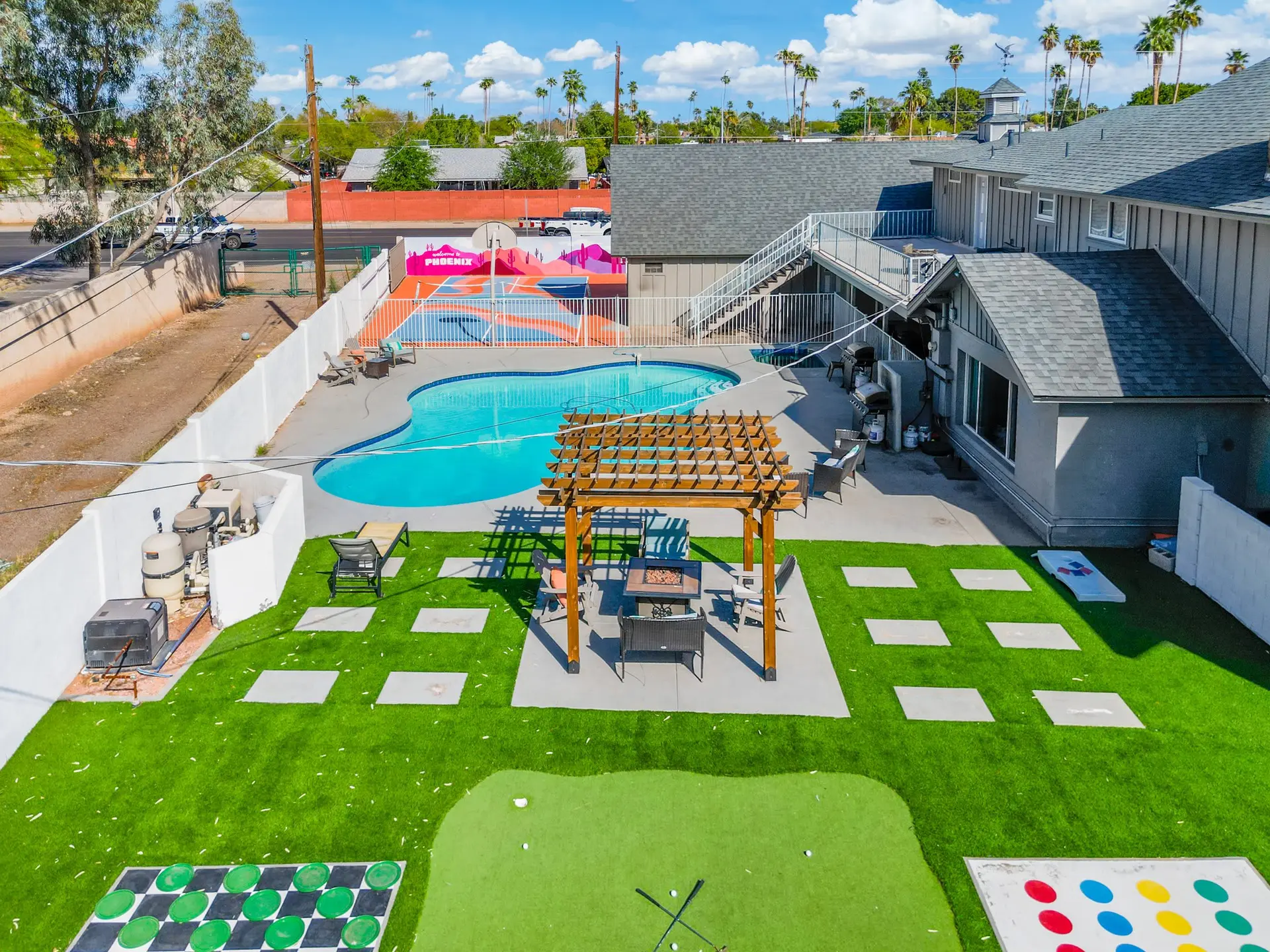 Backyard with pool, putting green, checkers, and games.
