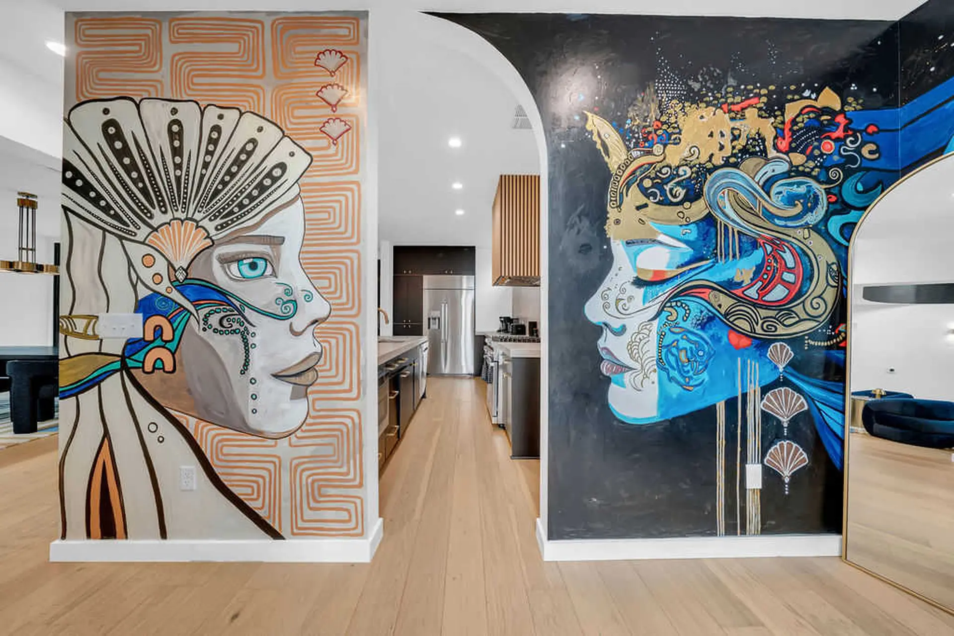 A hallway with two murals of stylized faces on either side.