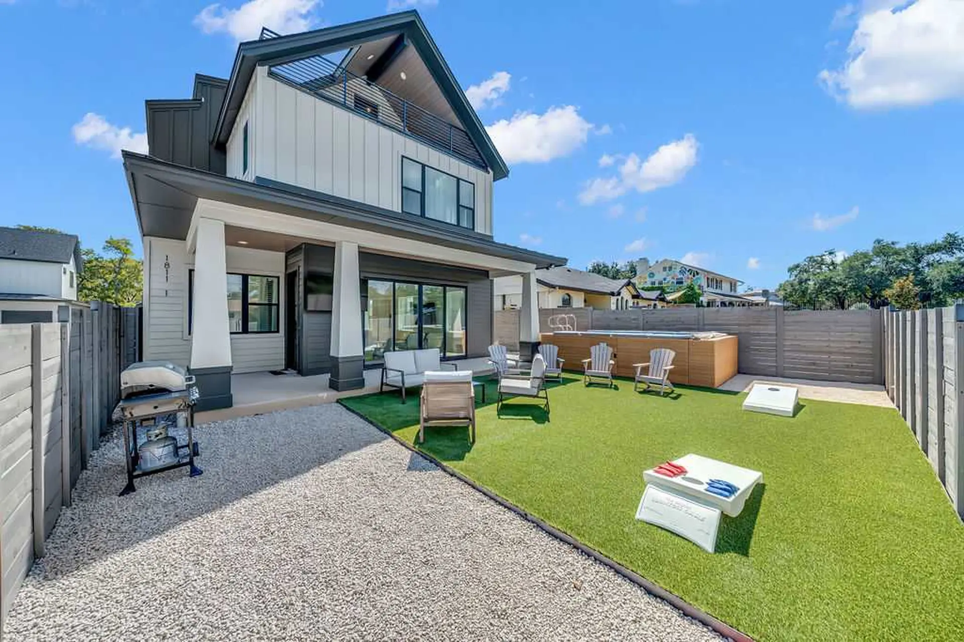 Modern house with hot tub, backyard seating, and games.