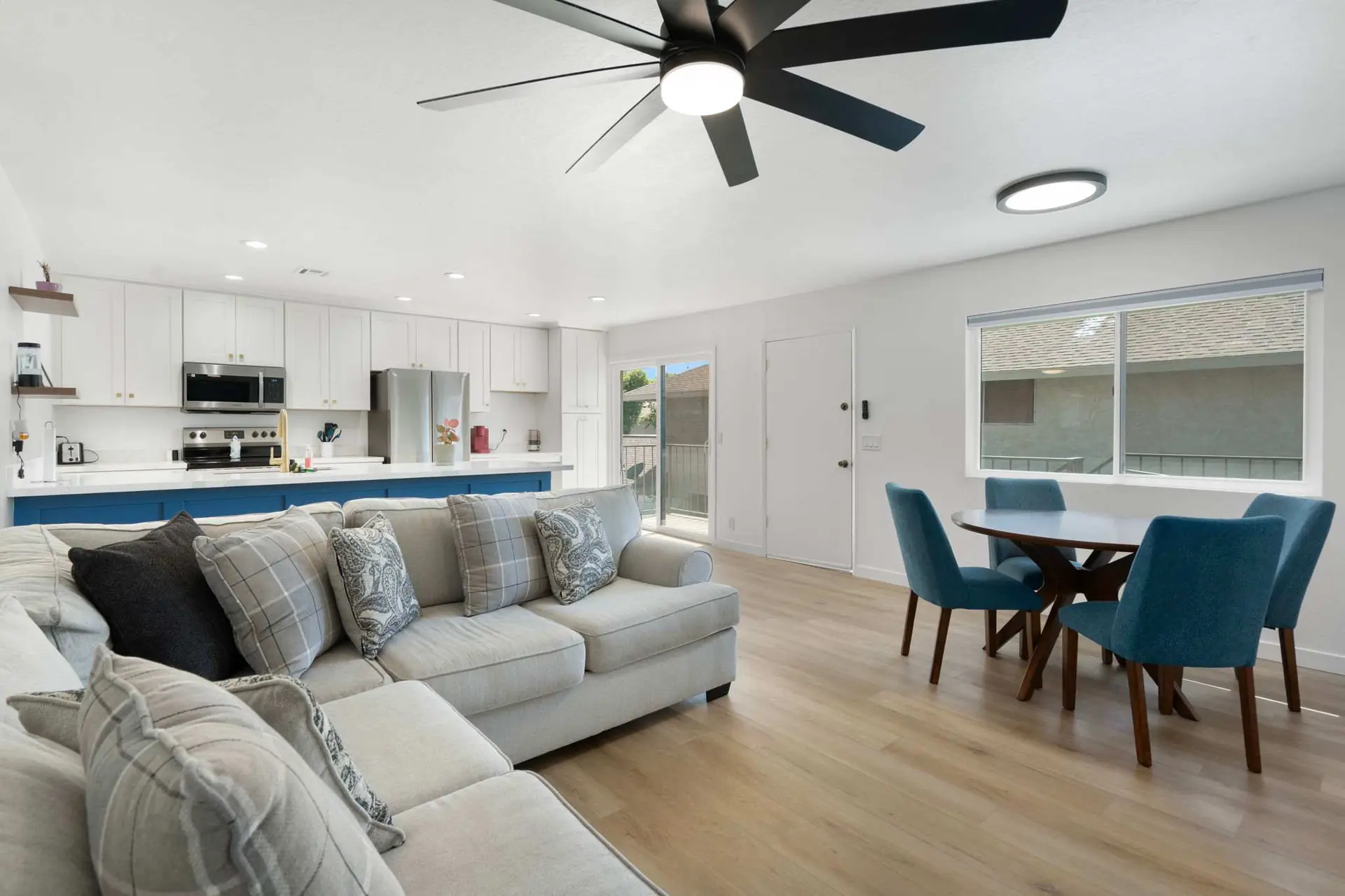 Modern living room and kitchen with dining table and chairs.