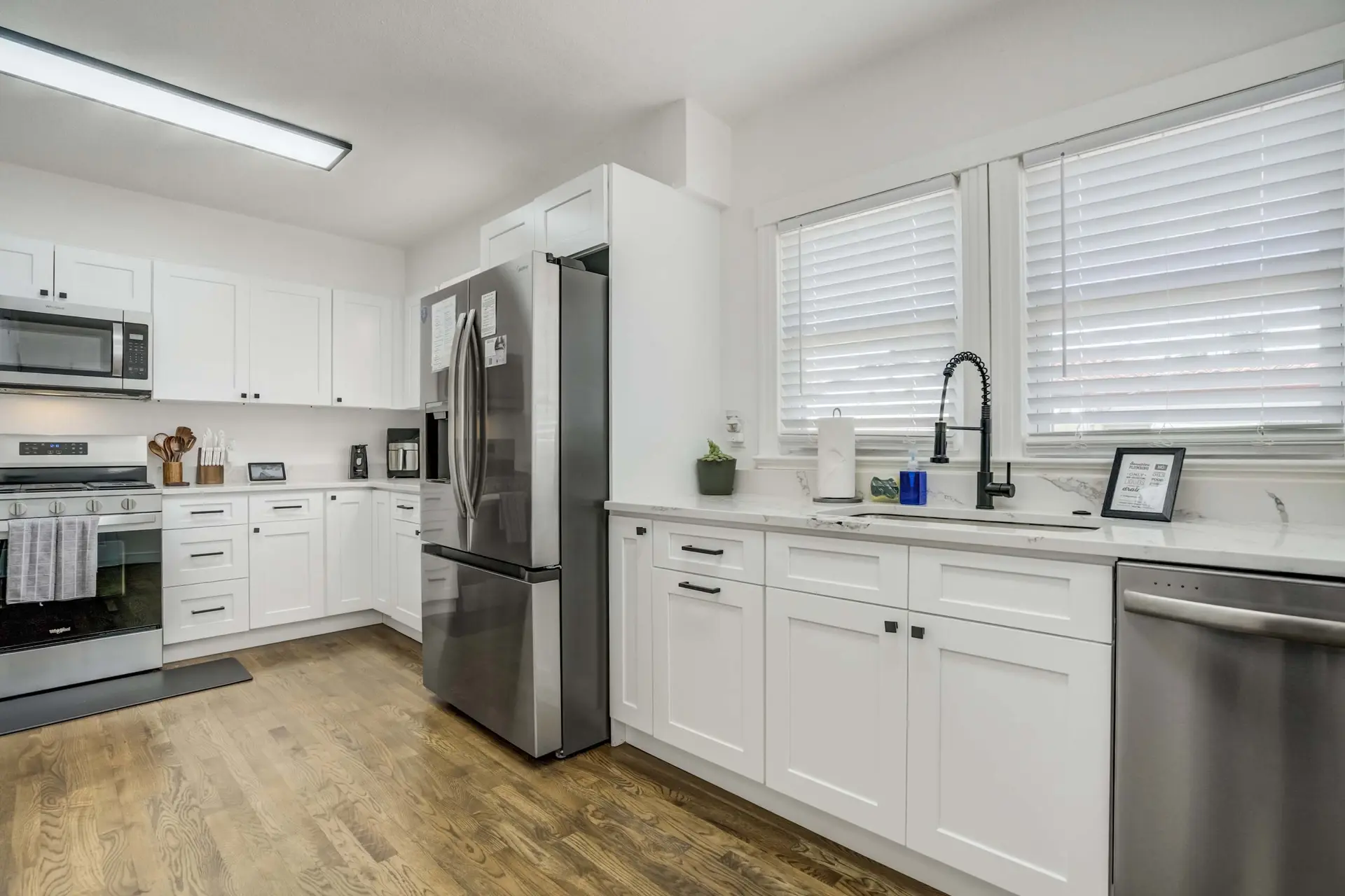 A modern kitchen with stainless steel appliances and white cabinets.