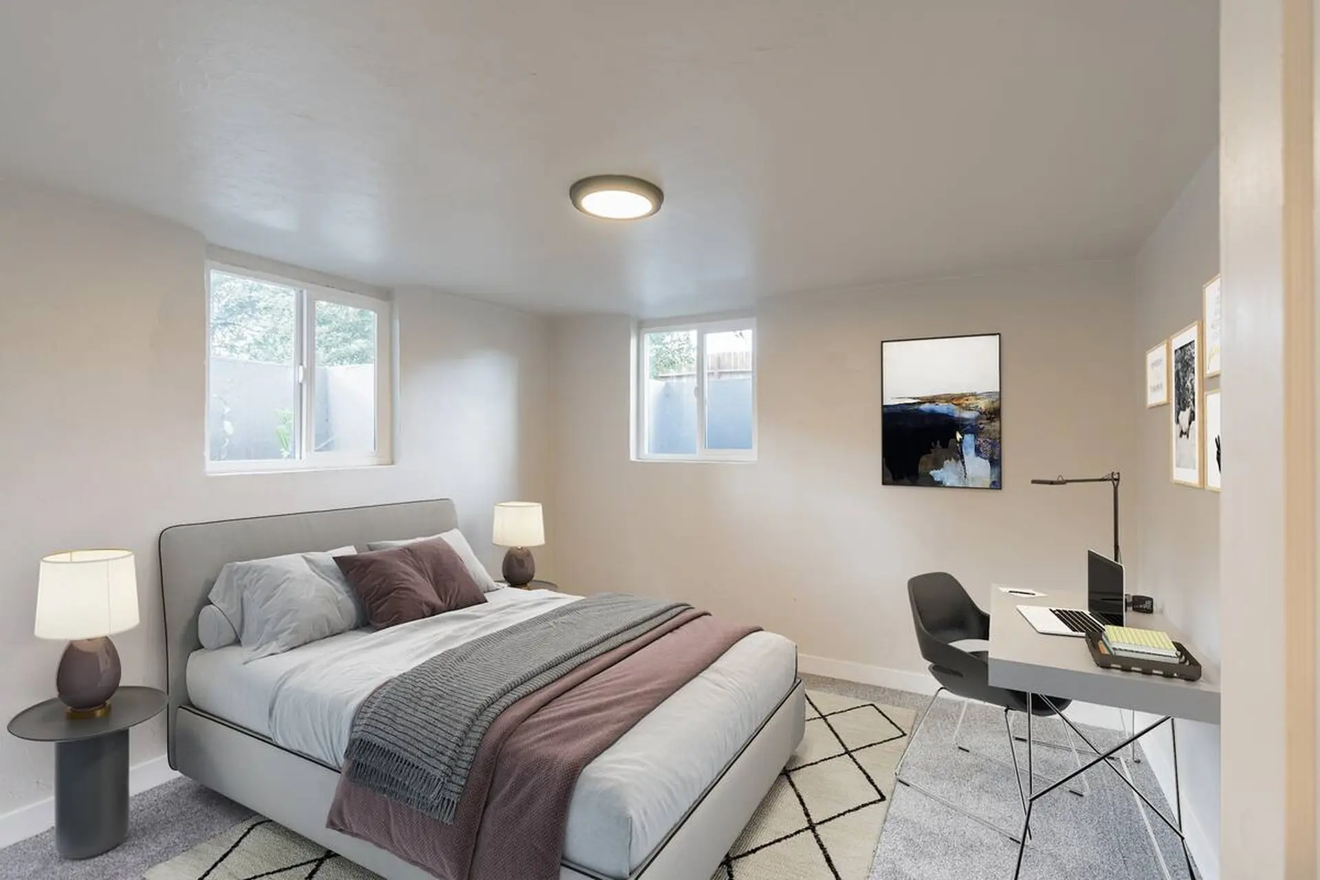 Bedroom with a bed, desk, and artwork on the wall.