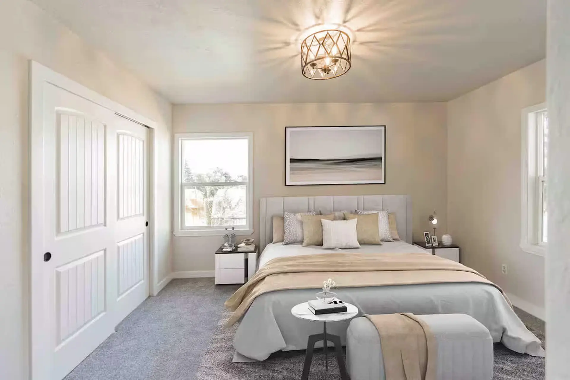 A bright bedroom with white doors, a large bed, and a modern light fixture.