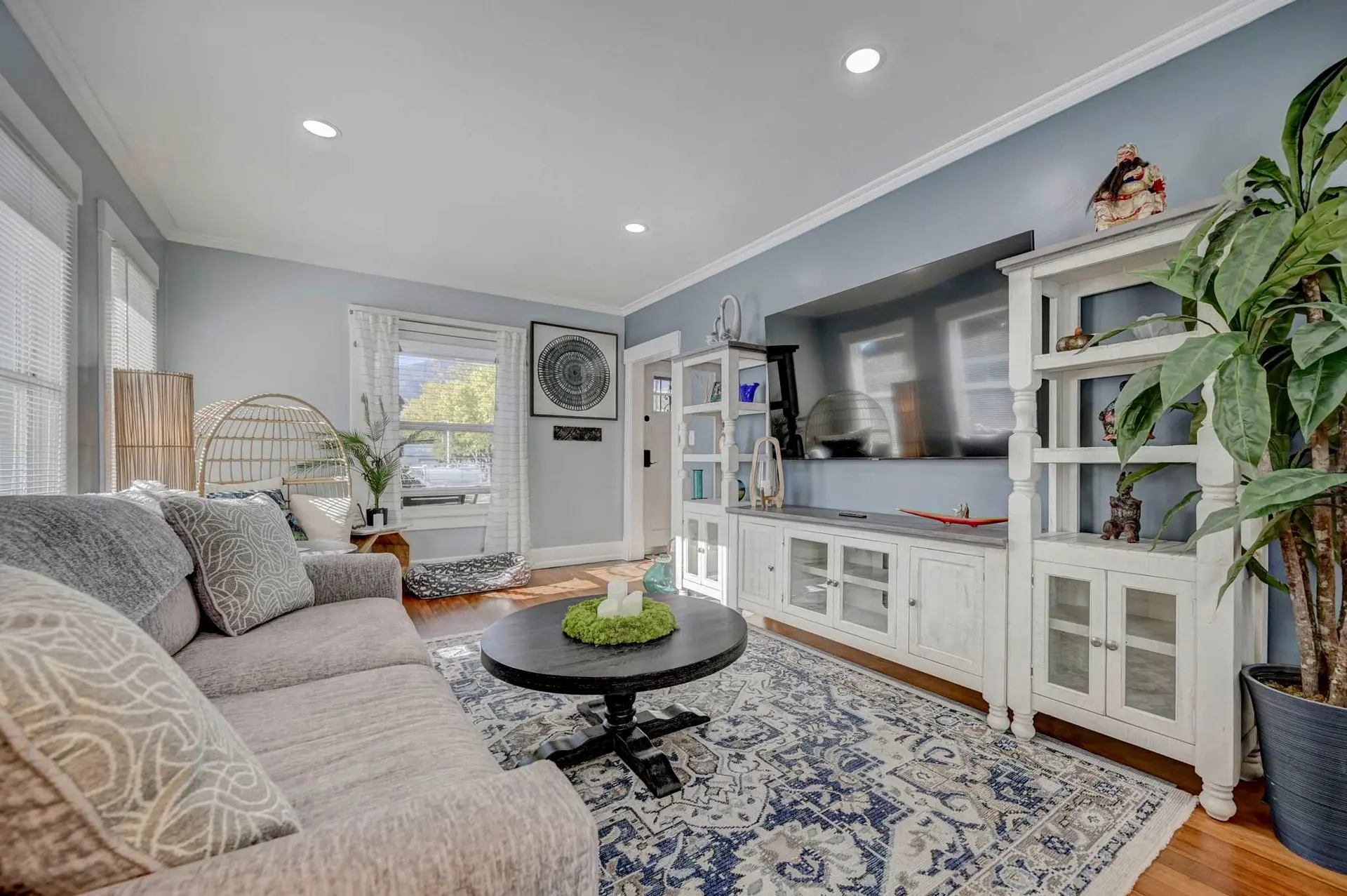 A living room with a gray sofa, coffee table, and a tv stand.