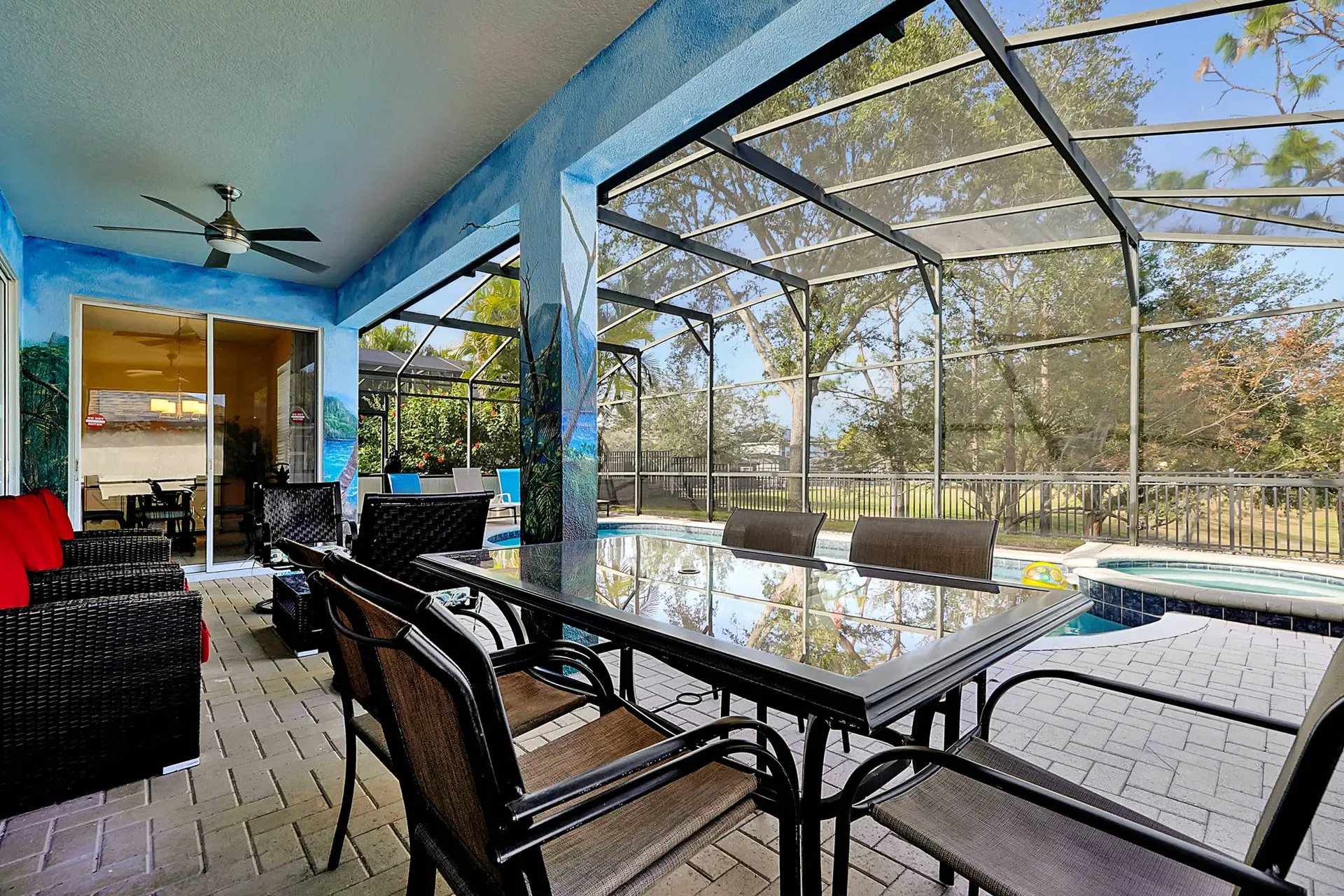 An outdoor patio area with a screened-in pool and hot tub.