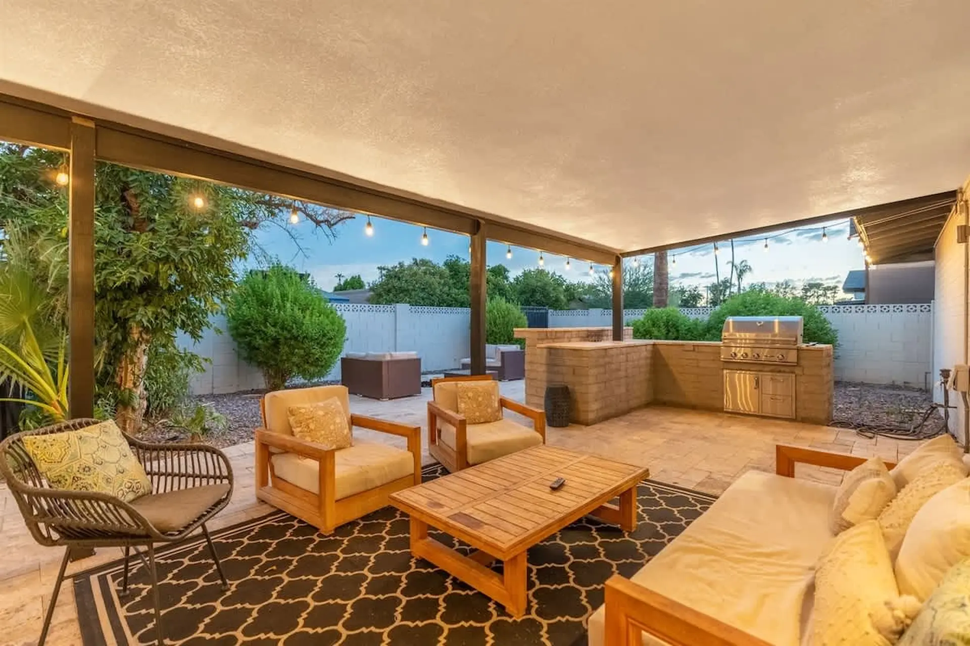 An inviting outdoor patio with a grill and seating area.