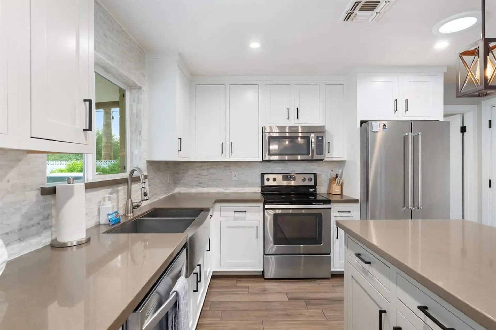 A clean, modern kitchen with white cabinets, stainless steel appliances, and granite countertops.