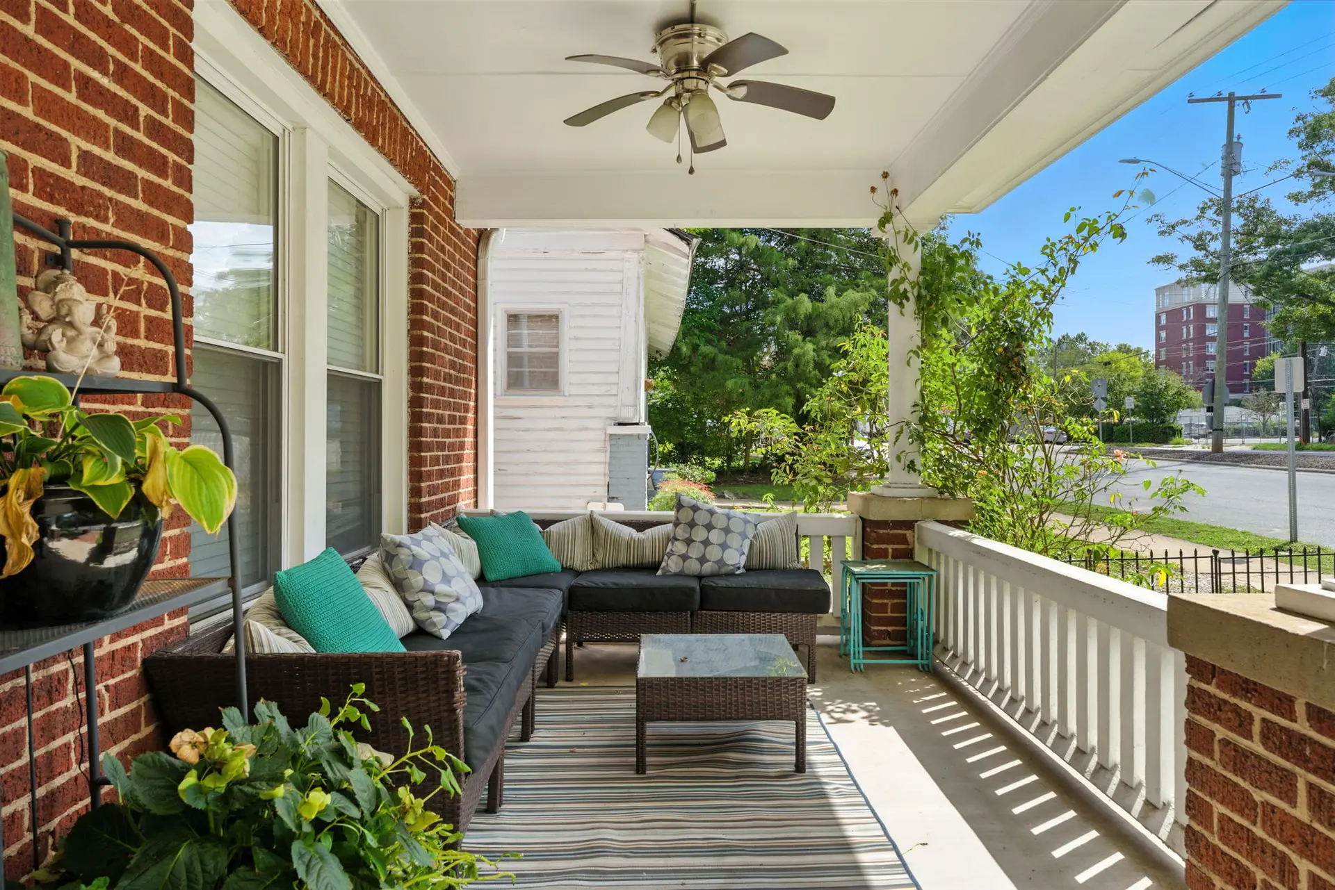 A porch with outdoor furniture and a ceiling fan.