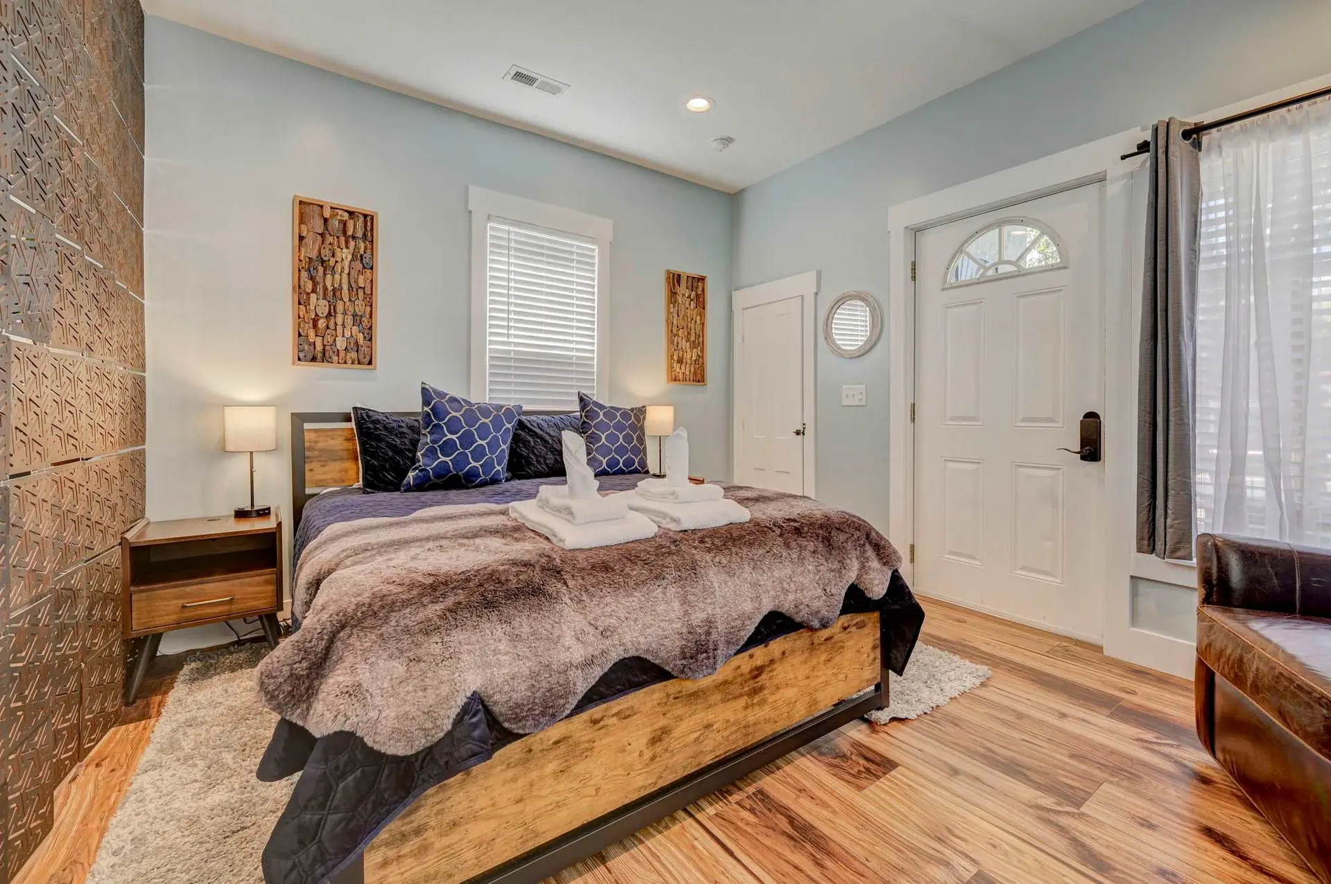 A cozy bedroom with a large bed, plush throw, and decorative pillows.
