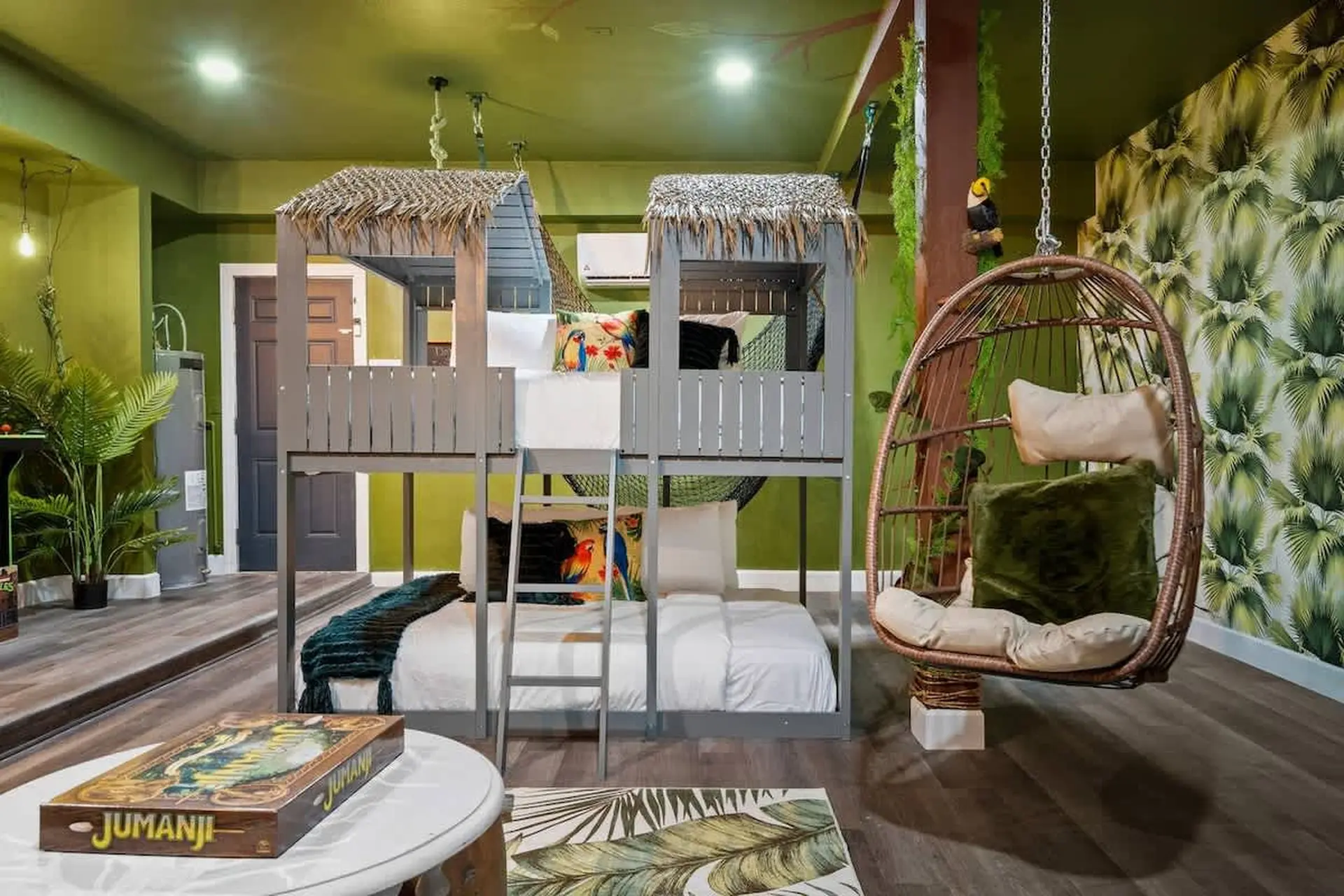 Jungle-themed bedroom with bunk beds and a hanging chair.