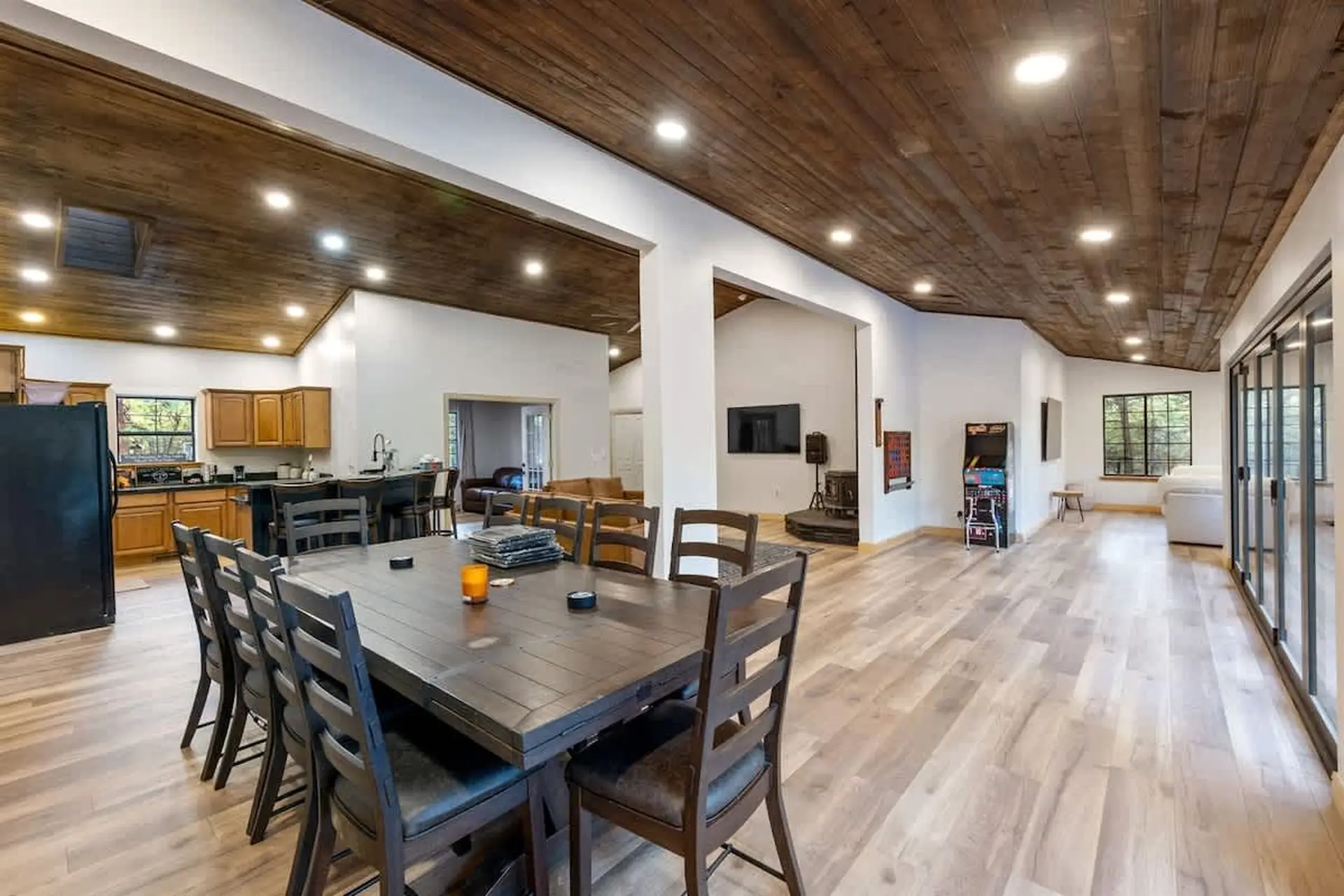 A spacious open-concept living area with a kitchen, dining table, and entertainment zone.