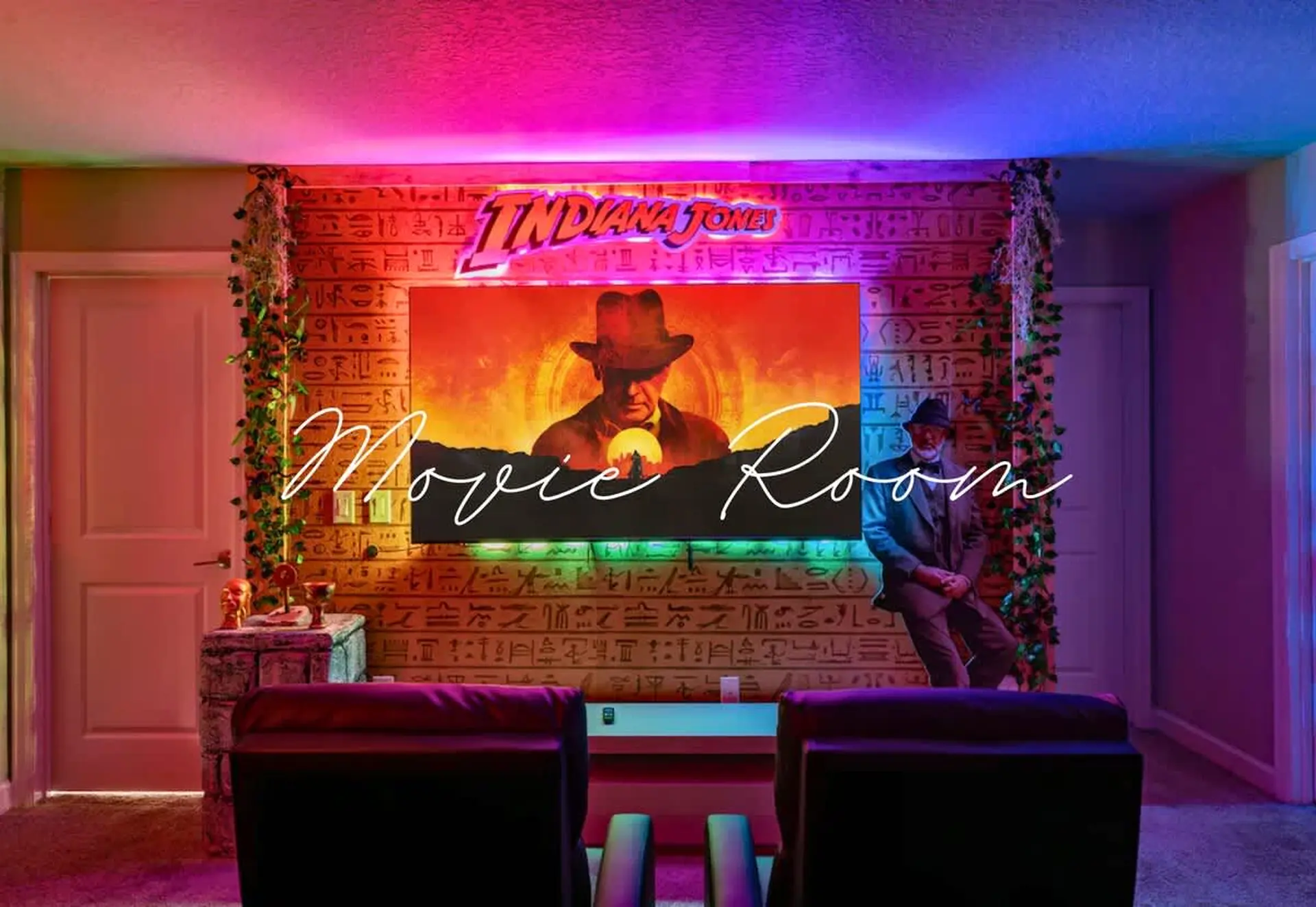 Indiana Jones themed movie room with Egyptian hieroglyphics, neon lights, and cozy seating.