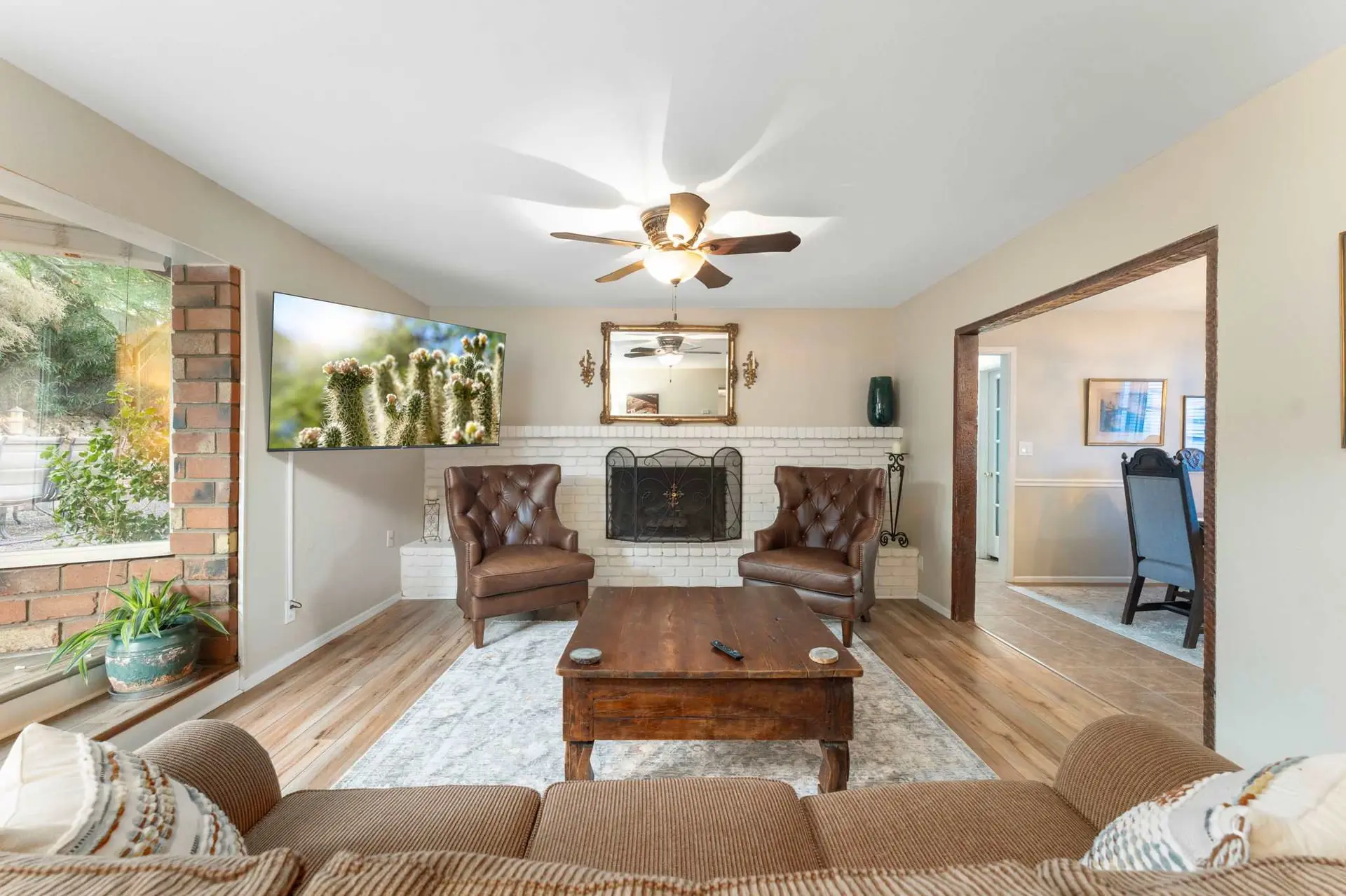 A living room with two brown leather armchairs, a wooden coffee table, and a TV.
