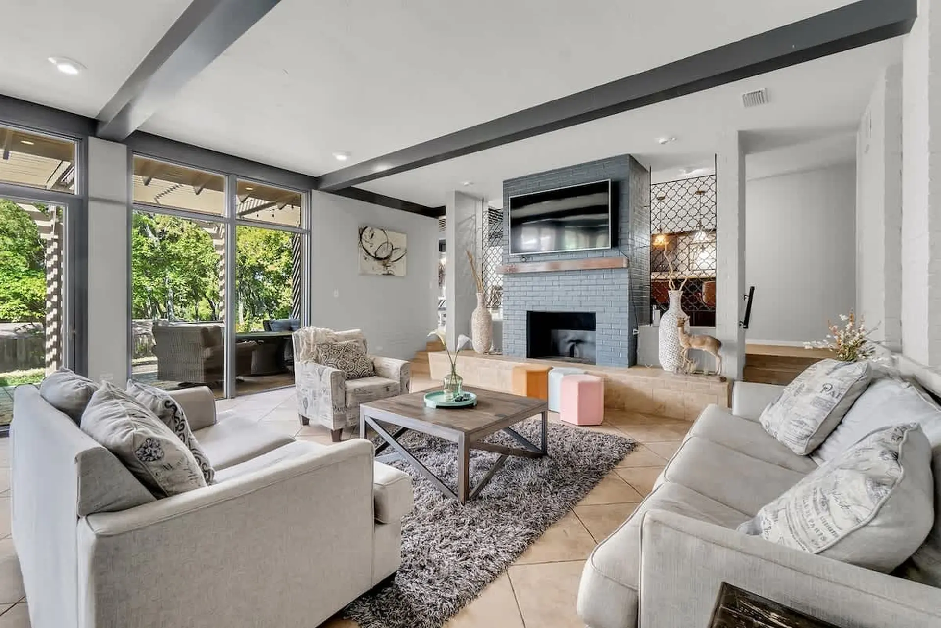 A living room with a fireplace, TV, coffee table, couches, and armchair.