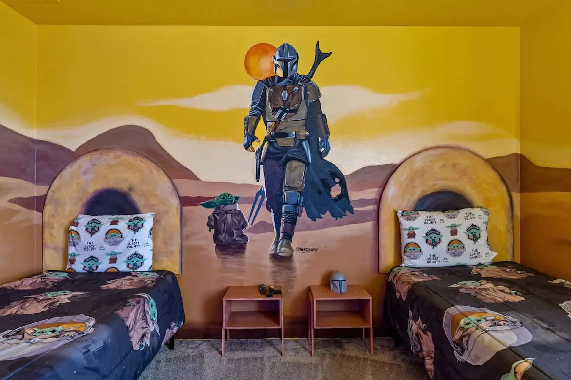 A bedroom with a mural of the Mandalorian and Grogu on a desert planet.