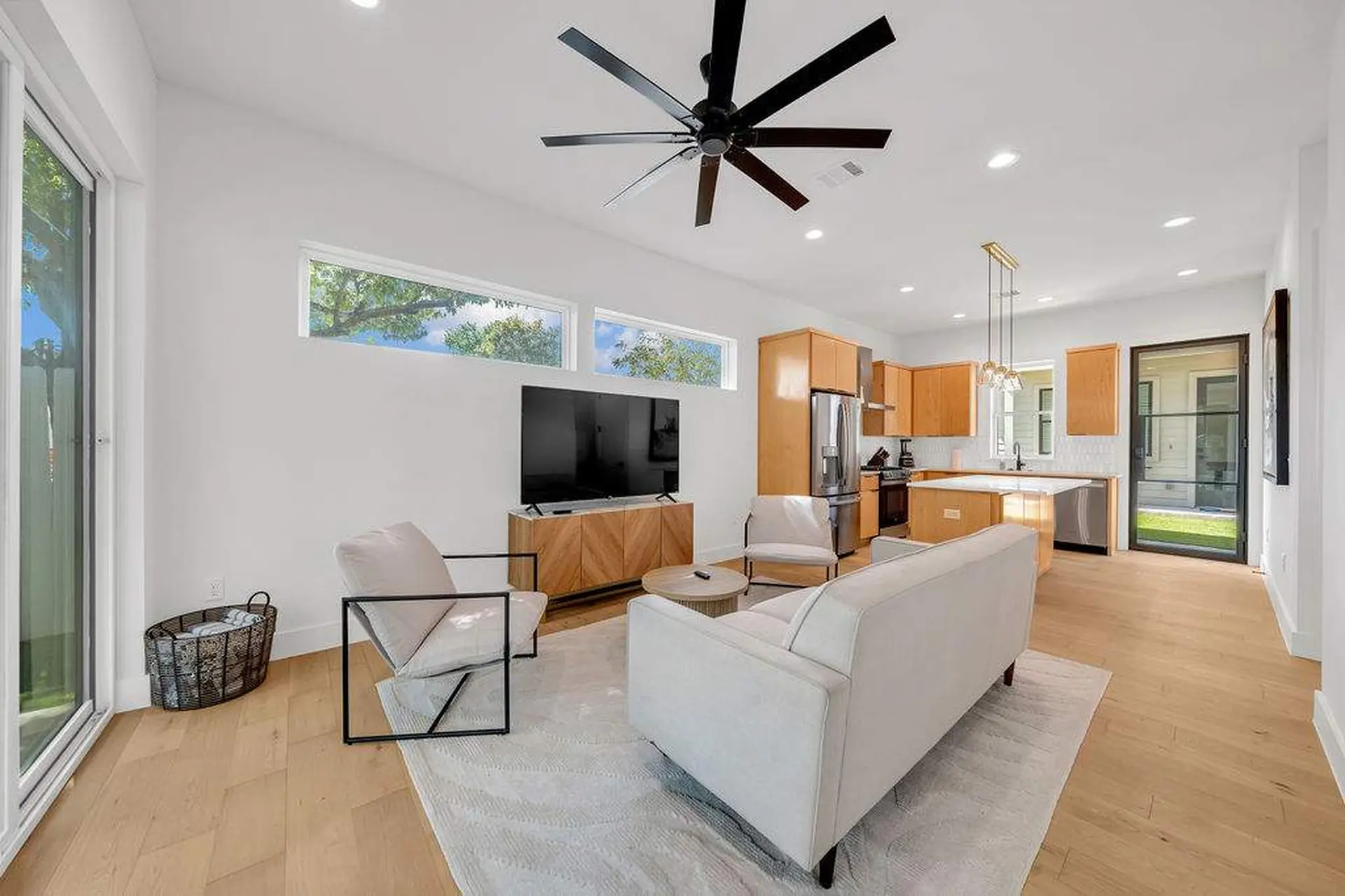 A modern living room with a TV, fireplace, and kitchen.