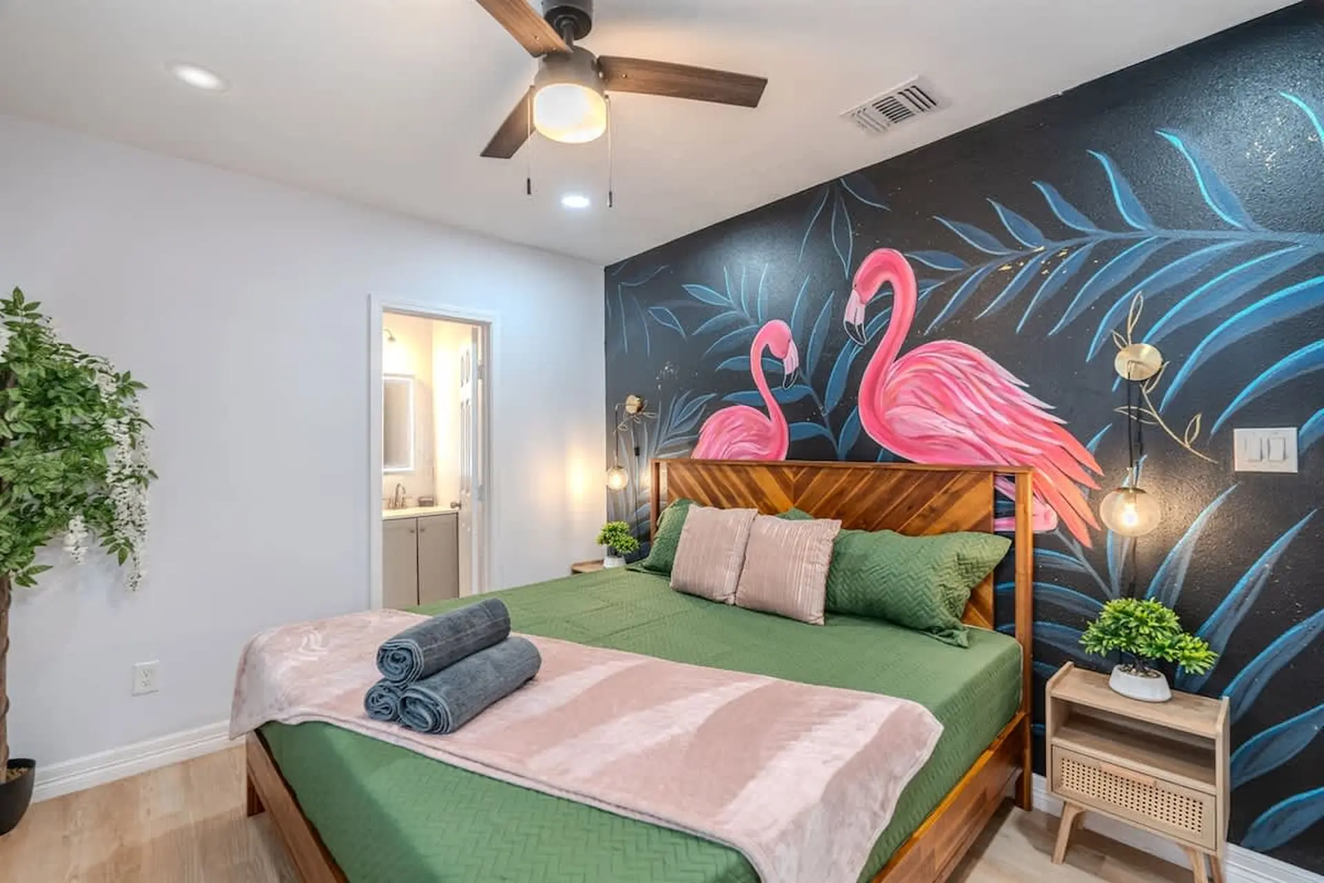 Bedroom with a tropical flamingo mural, a wooden bed, and a ceiling fan.
