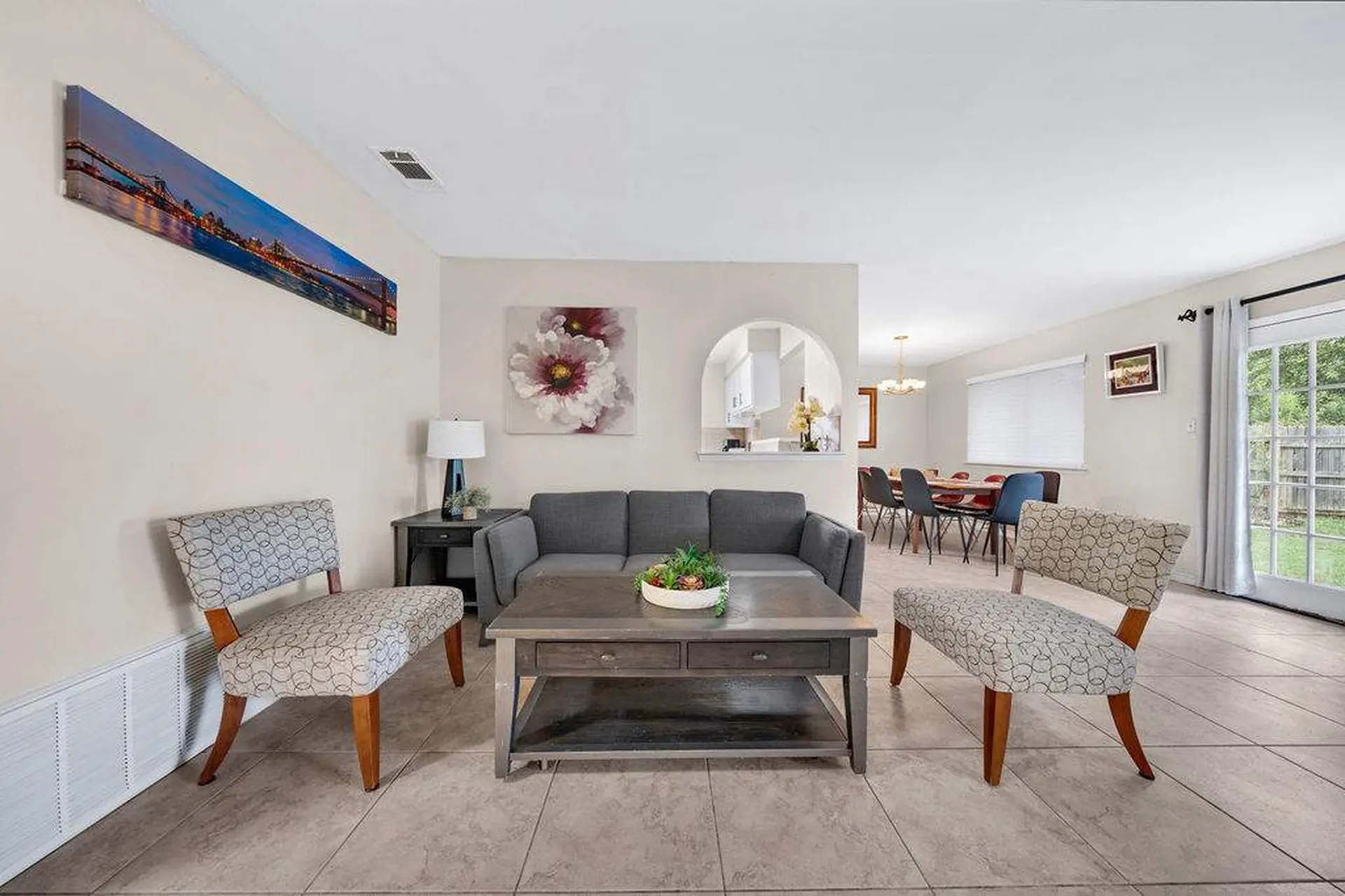 Living room with gray sofa, coffee table, and patterned accent chairs.